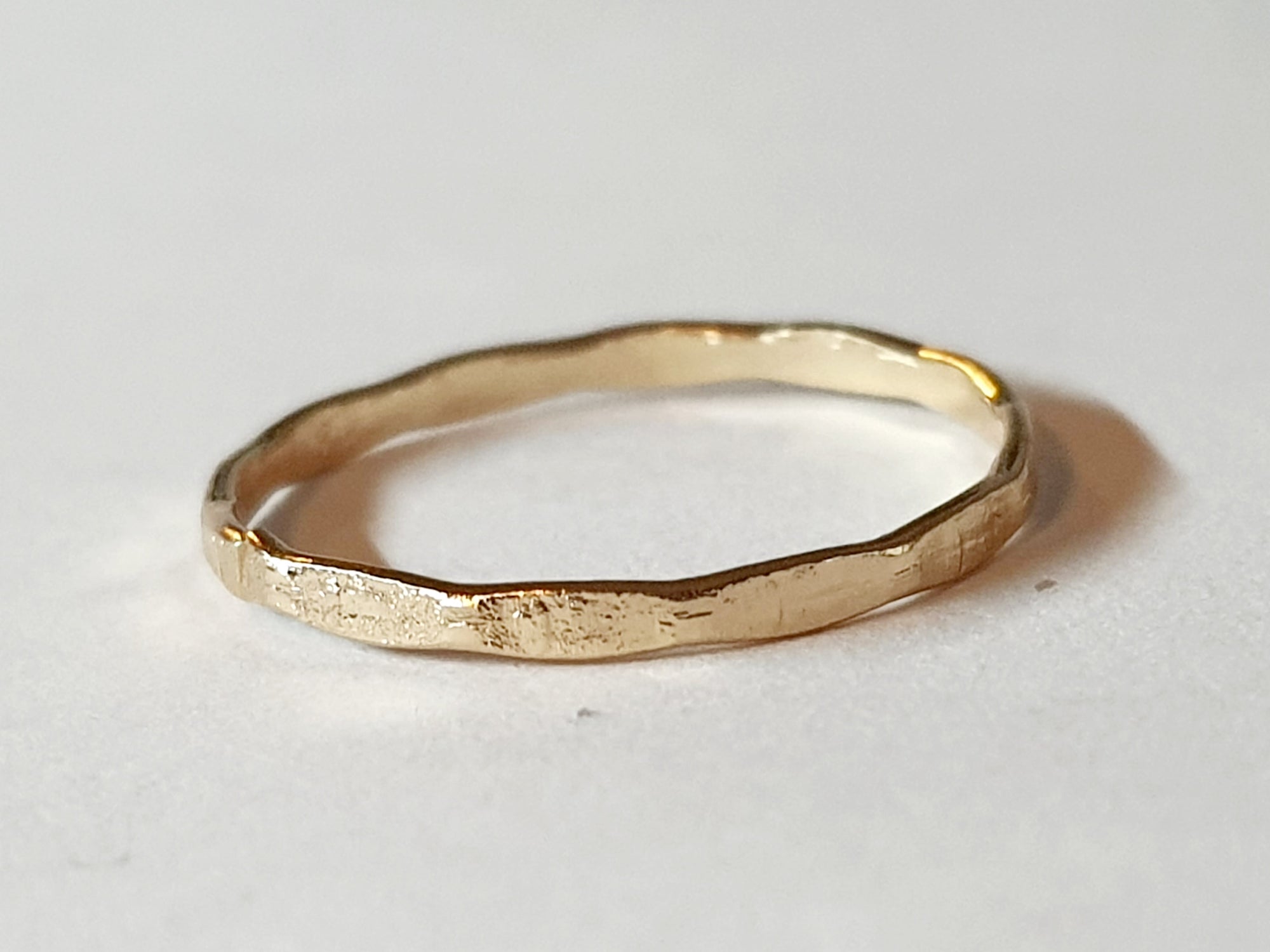 Złota obrączka ze stali chirurgicznej, młotkowana, o nieregularnej powierzchni i połysku, rozmiar 16 mm, minimalistyczny design. Stal nierdzewna, wodoodporne, hipoalergiczne, jakość premium. Rouge Bizu.