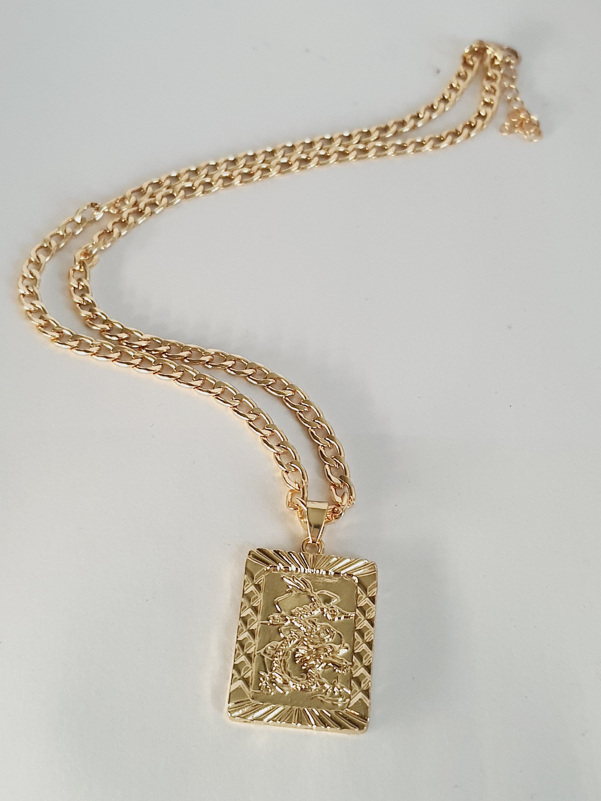 Złoty naszyjnik ze stali nierdzewnej, prostokątna zawieszka z motywem smoka w reliefie, długość 45–50 cm, styl elegancki i symboliczny, RougeBizu.