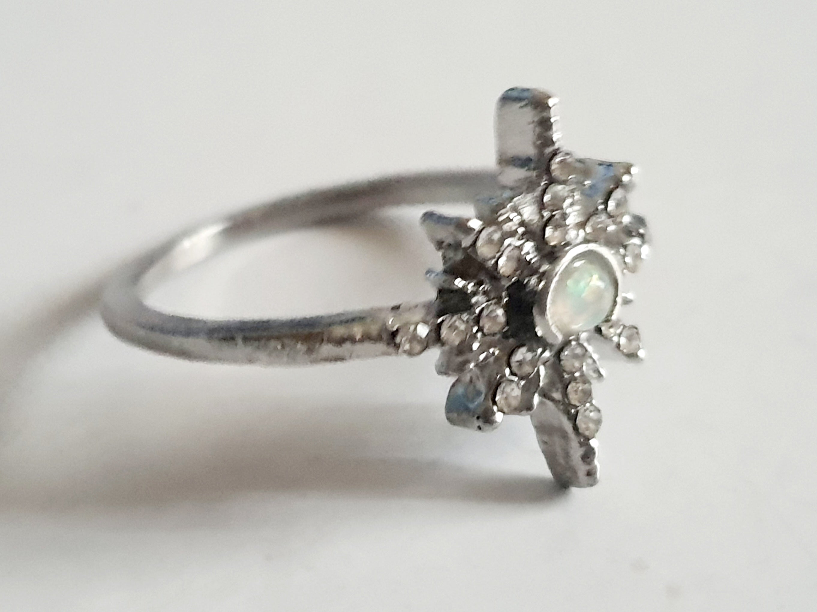 Srebrny pierścionek ze stali nierdzewnej i chirurgicznej z opalizującym kamieniem i cyrkoniami w kształcie gwiazdy, styl glamour i romantyczny, rozmiar 18 mm. Wodoodporny, hipoalergiczny, jakość premium. Rouge Bizu.