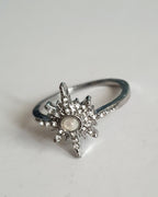 Srebrny pierścionek ze stali nierdzewnej i chirurgicznej z opalizującym kamieniem i cyrkoniami w kształcie gwiazdy, styl glamour i romantyczny, rozmiar 18 mm. Wodoodporny, hipoalergiczny, jakość premium. Rouge Bizu.