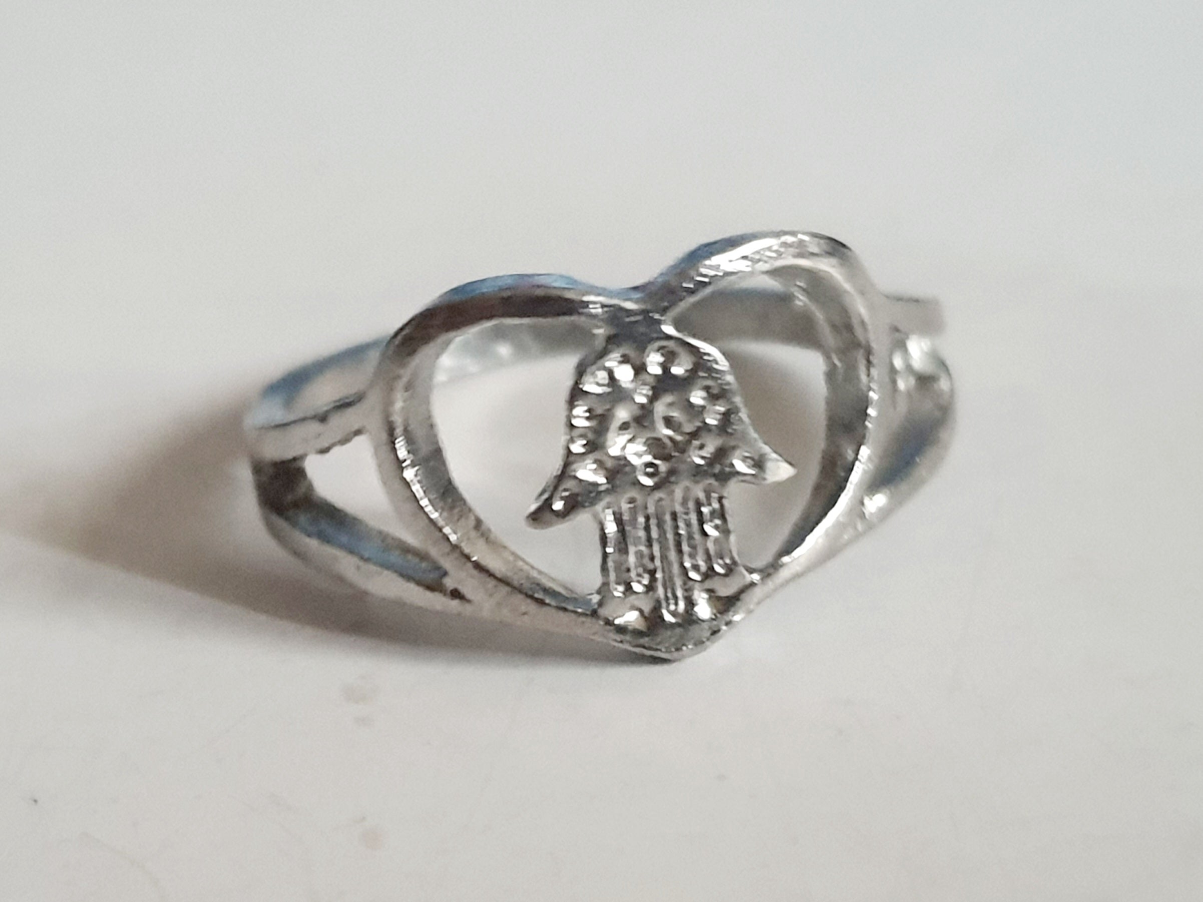 Srebrny pierścionek ze stali nierdzewnej i chirurgicznej z motywem dłoni Fatimy w sercu, symboliczny amulet, rozmiar 18 mm. Wodoodporny, hipoalergiczny, jakość premium. Rouge Bizu.