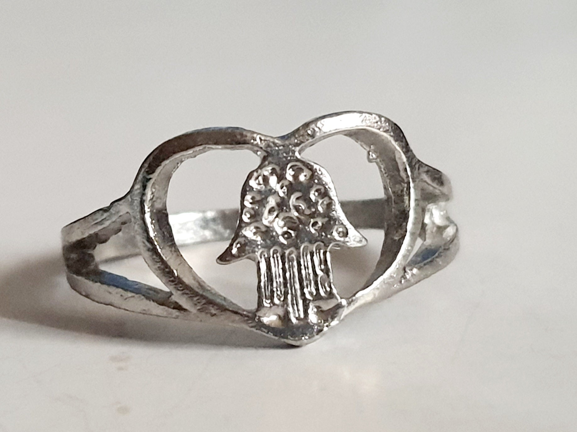 Srebrny pierścionek ze stali nierdzewnej i chirurgicznej z motywem dłoni Fatimy w sercu, symboliczny amulet, rozmiar 18 mm. Wodoodporny, hipoalergiczny, jakość premium. Rouge Bizu.