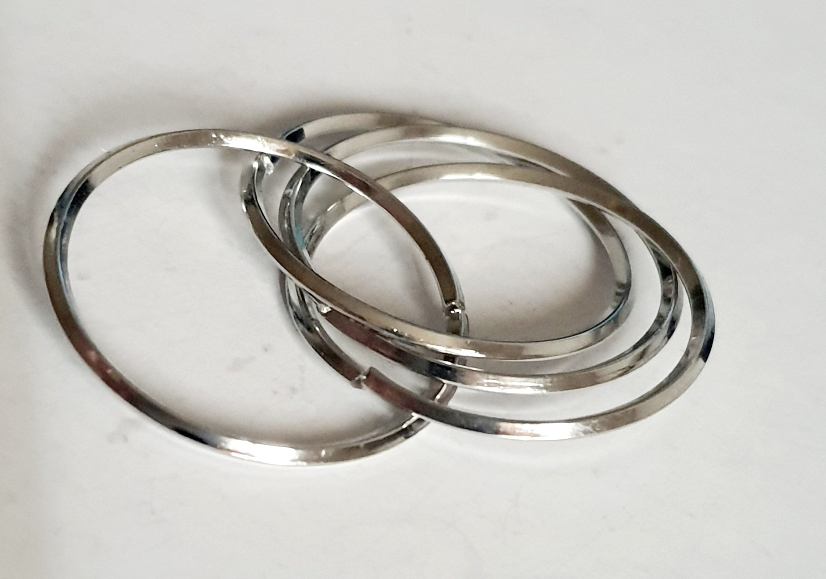 Srebrny pierścionek ze stali nierdzewnej i chirurgicznej z trzech przeplatających się obręczy, styl minimalistyczny i elegancki, rozmiar 20 mm. Wodoodporny, hipoalergiczny, jakość premium. Rouge Bizu.