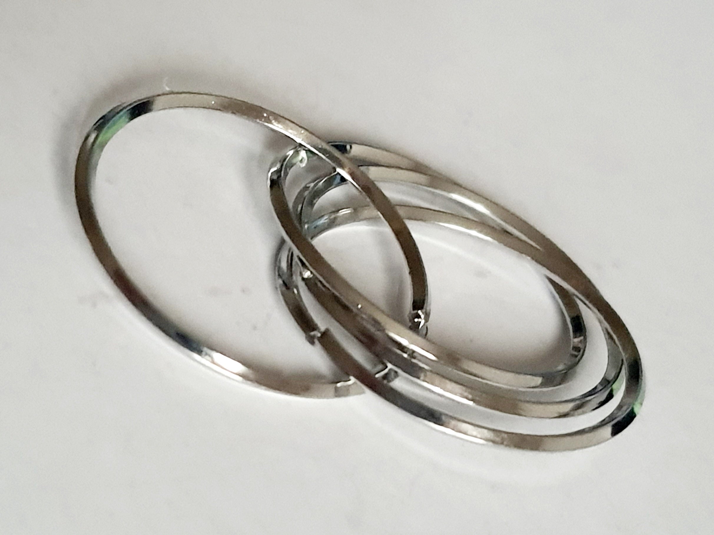 Srebrny pierścionek ze stali nierdzewnej i chirurgicznej z trzech przeplatających się obręczy, styl minimalistyczny i elegancki, rozmiar 20 mm. Wodoodporny, hipoalergiczny, jakość premium. Rouge Bizu.