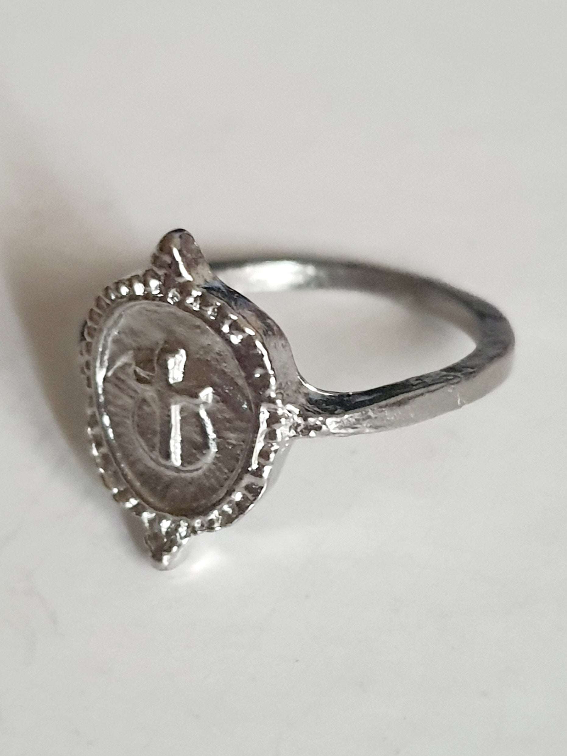 Srebrny pierścionek ze stali nierdzewnej i chirurgicznej z motywem kotwicy i krzyża na okrągłej tarczy, styl vintage i symboliczny, rozmiar 16 mm. Wodoodporny, hipoalergiczny, jakość premium. Rouge Bizu.