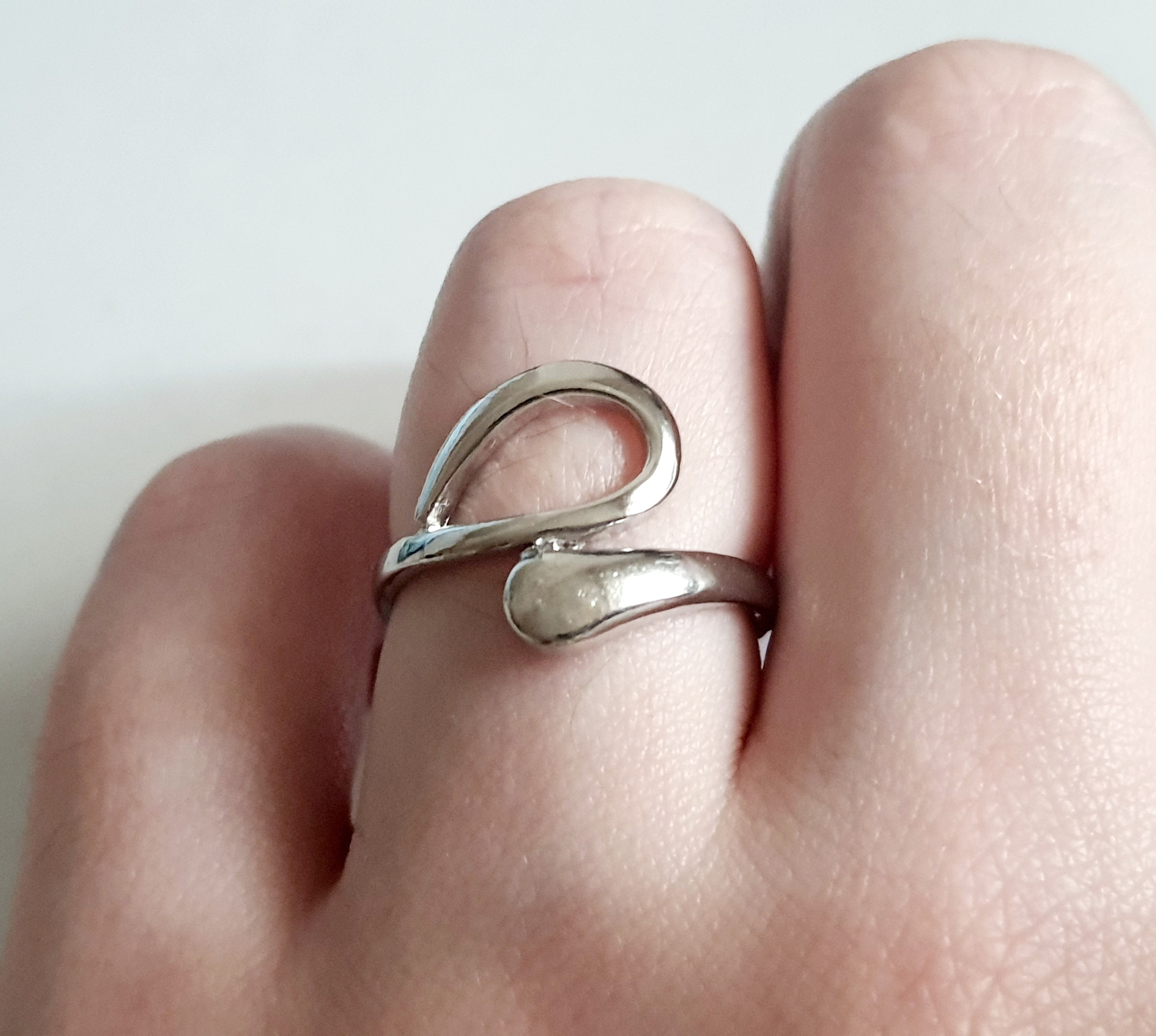 Srebrny pierścionek ze stali nierdzewnej i chirurgicznej o falistym, otwartym kształcie w stylu minimalistycznym, rozmiar 17 mm. Wodoodporny, hipoalergiczny, jakość premium. Rouge Bizu.