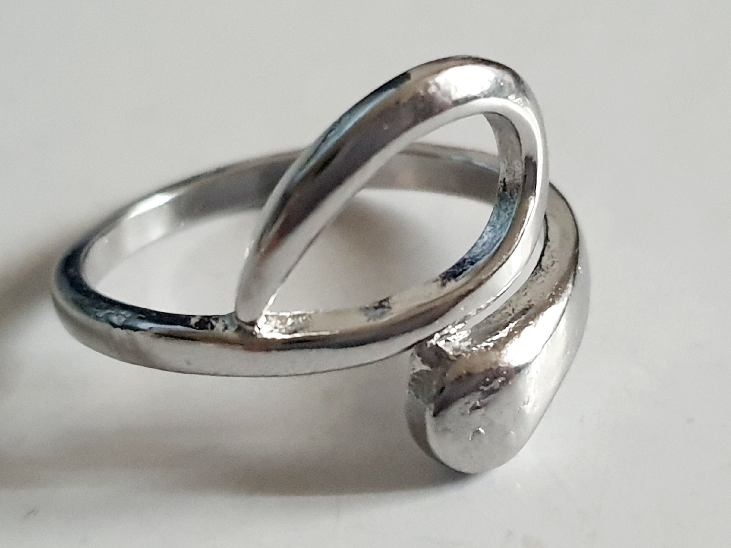 Srebrny pierścionek ze stali nierdzewnej i chirurgicznej o falistym, otwartym kształcie w stylu minimalistycznym, rozmiar 17 mm. Wodoodporny, hipoalergiczny, jakość premium. Rouge Bizu.