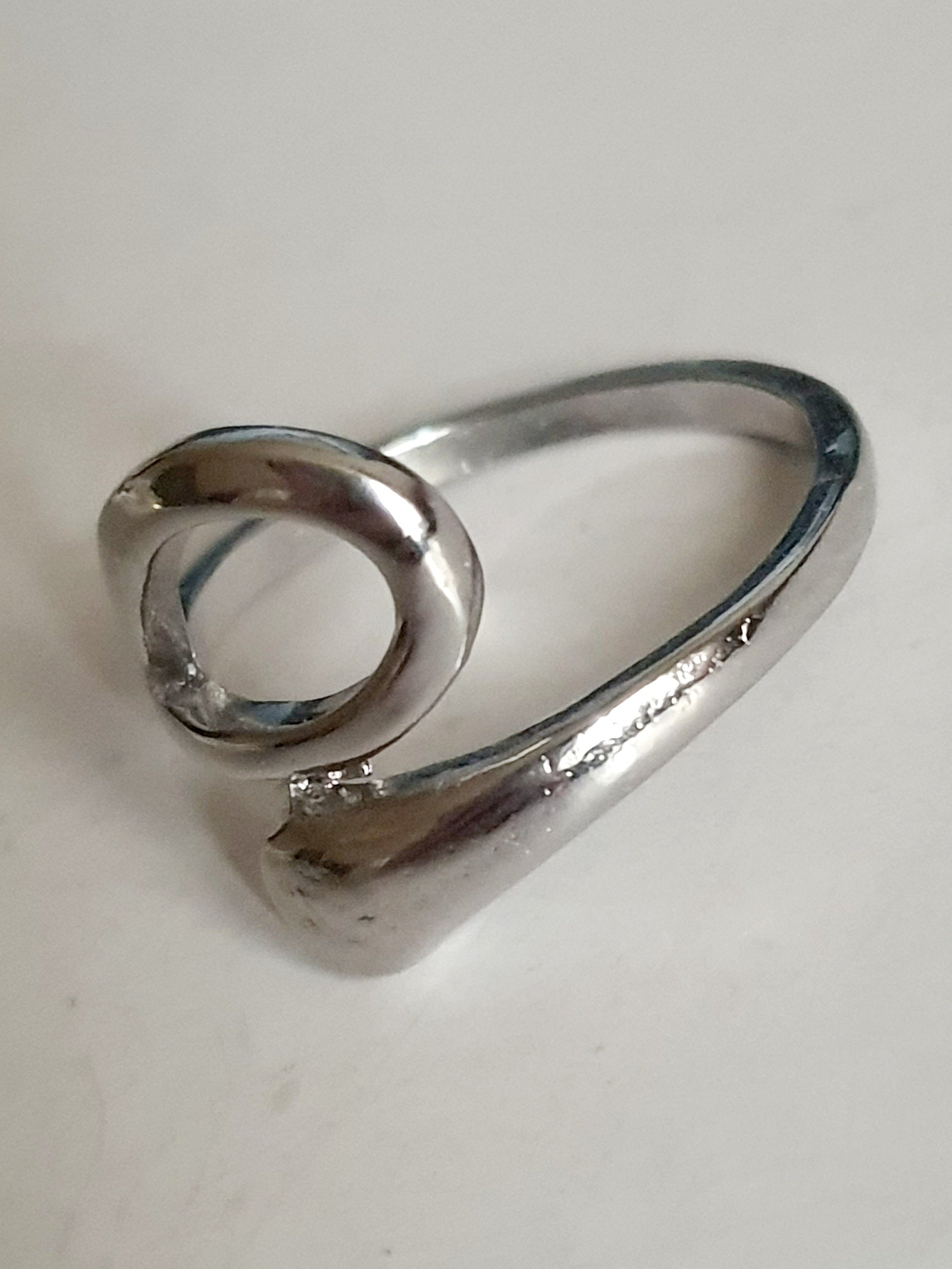 Srebrny pierścionek ze stali nierdzewnej i chirurgicznej o falistym, otwartym kształcie w stylu minimalistycznym, rozmiar 17 mm. Wodoodporny, hipoalergiczny, jakość premium. Rouge Bizu.