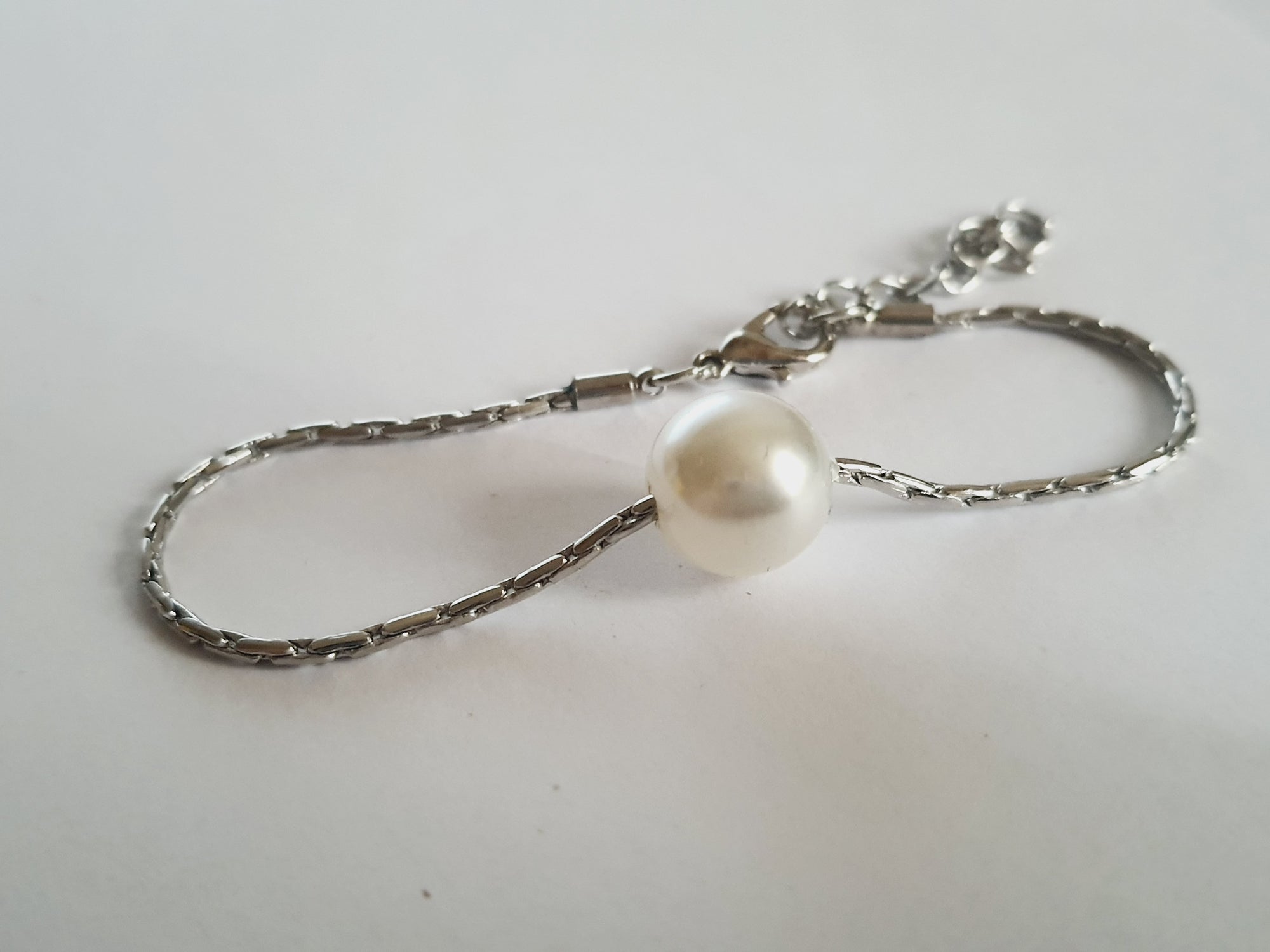 Srebrna bransoletka z dużą białą perłą na środku, elegancka i klasyczna. Stal nierdzewna, stal chirurgiczna, wodoodporne, hipoalergiczne, jakość premium, Rouge Bizu.