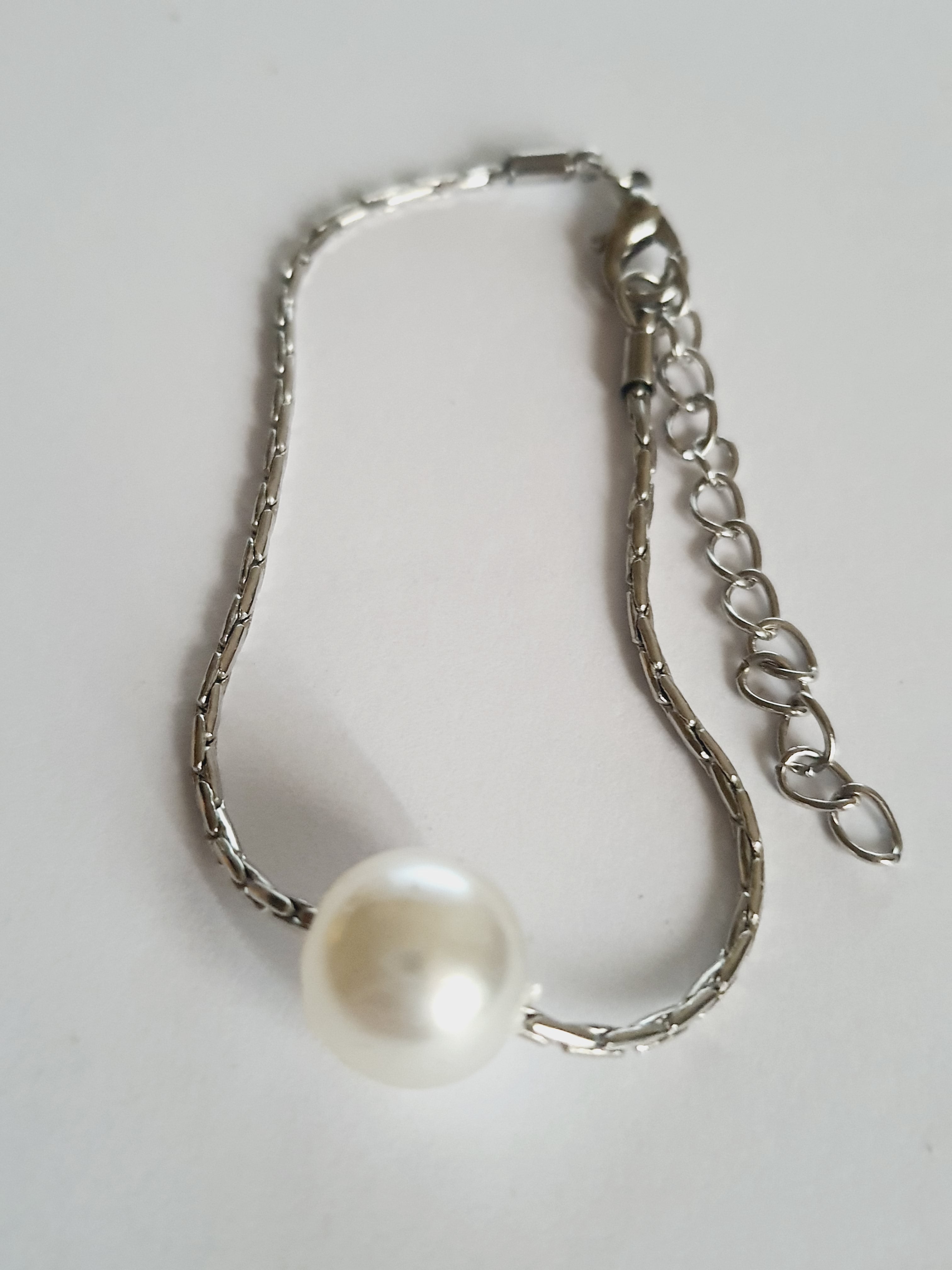 Srebrna bransoletka z dużą białą perłą na środku, elegancka i klasyczna. Stal nierdzewna, stal chirurgiczna, wodoodporne, hipoalergiczne, jakość premium, Rouge Bizu.