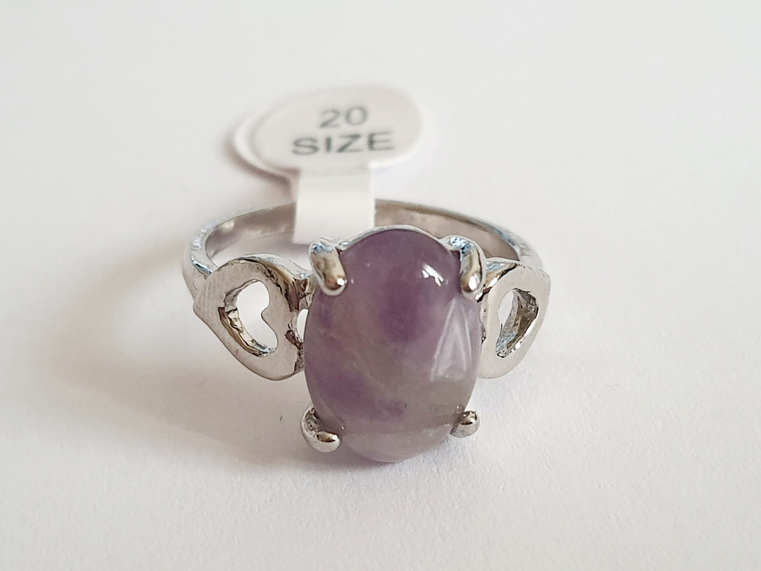 Srebrny pierścionek ze stali nierdzewnej z owalnym kamieniem w odcieniu lila i ozdobnym wycięciem po bokach. Styl romantyczny, artystyczny. Rozmiar 20 mm. Rouge Bizu.

