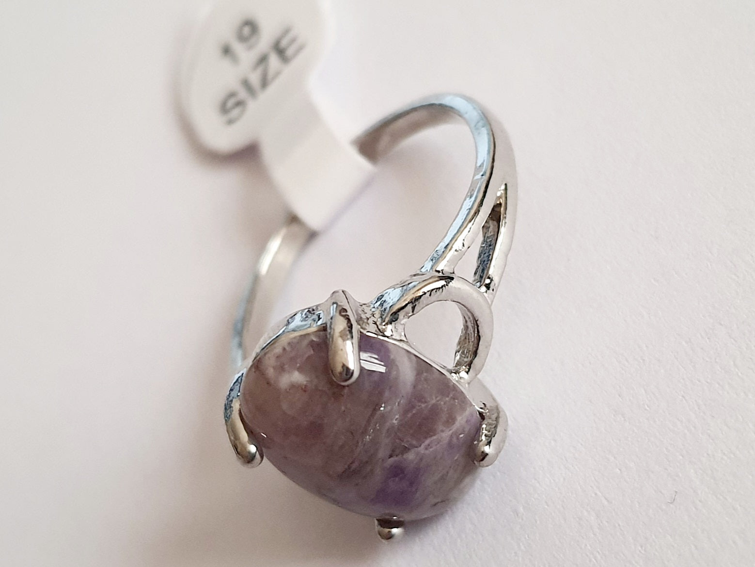 Pierścionek ze stali nierdzewnej w kolorze srebra z dużym owalnym kamieniem w odcieniu ametystowego fioletu. Styl klasyczny, elegancki. Rozmiar 19 mm. Rouge Bizu.

