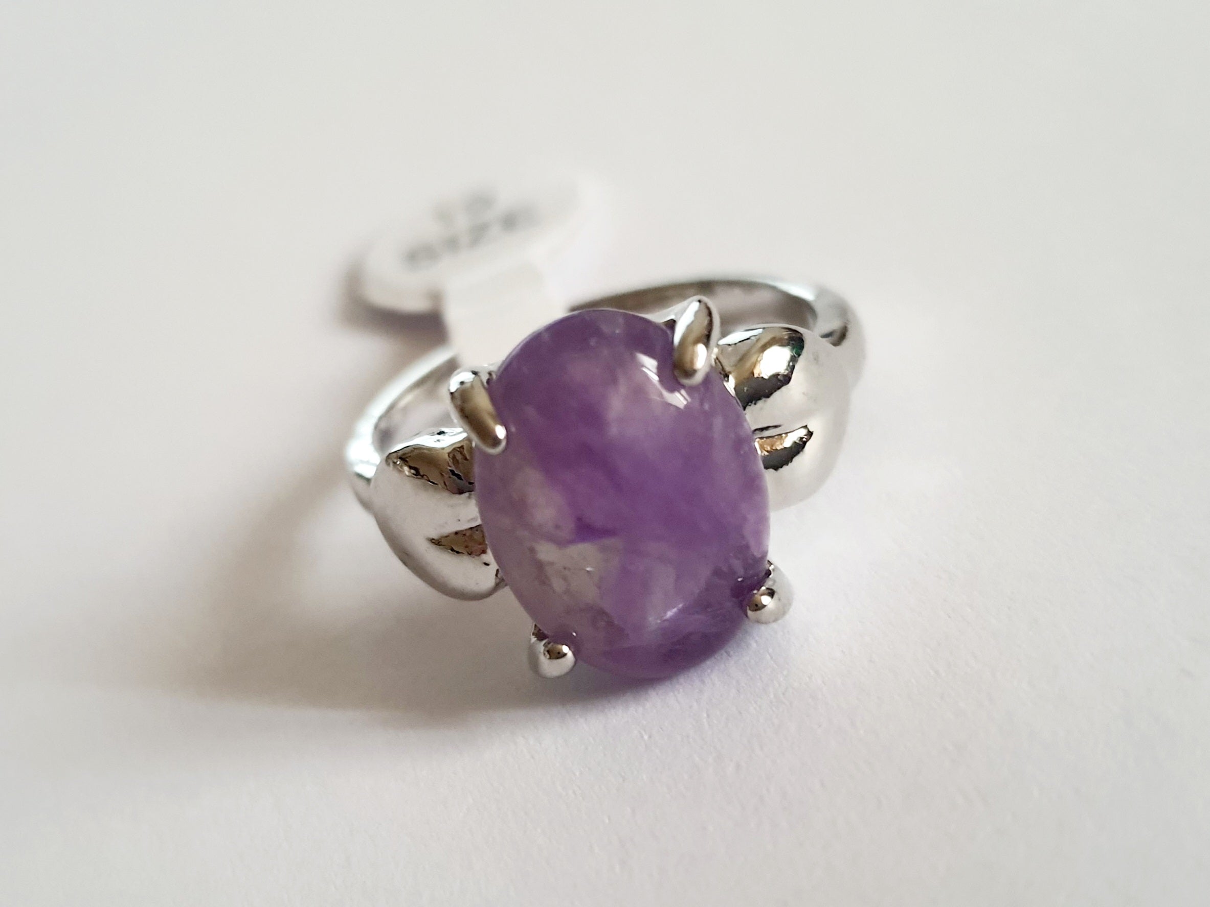 Pierścionek ze stali chirurgicznej z lawendowym kamieniem, owalnym kaboszonem i oprawą w formie liści. Styl vintage i naturalna elegancja. Rozmiar 19 mm. Rouge Bizu.

