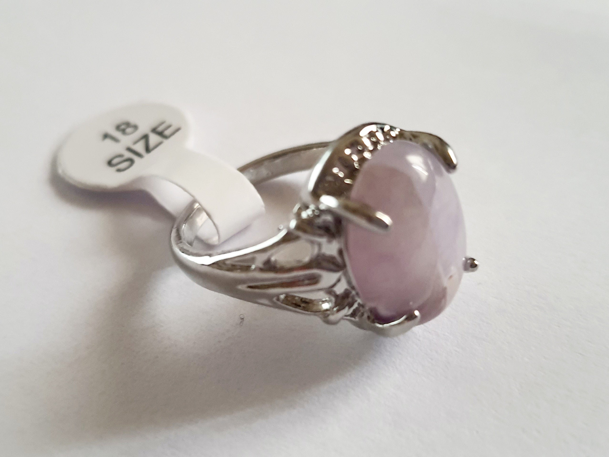 Srebrny pierścionek z pastelowym, liliowym kamieniem, wykonany ze stali nierdzewnej. Subtelny design i gładka oprawa, rozmiar 18 mm. Delikatna elegancja i codzienny szyk. Rouge Bizu.

