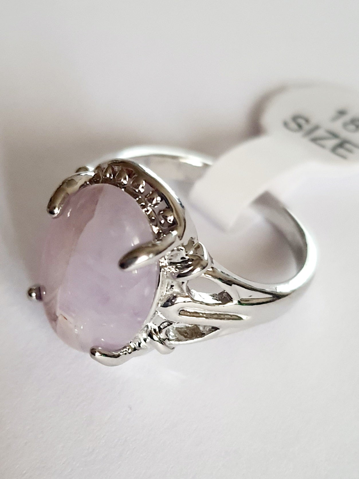 Srebrny pierścionek z pastelowym, liliowym kamieniem, wykonany ze stali nierdzewnej. Subtelny design i gładka oprawa, rozmiar 18 mm. Delikatna elegancja i codzienny szyk. Rouge Bizu.

