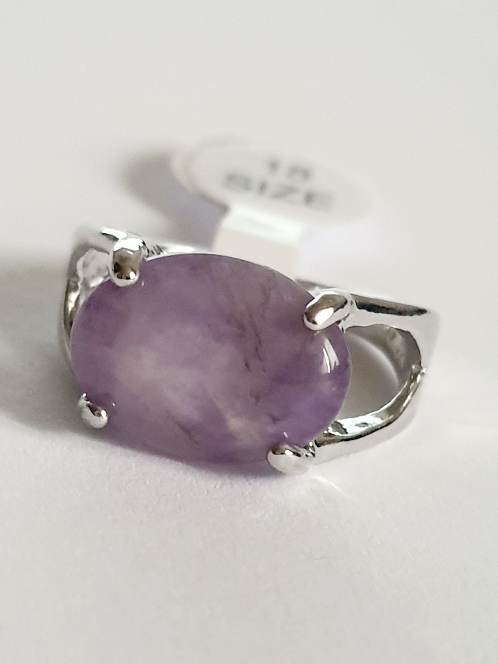 Srebrny pierścionek ze stali nierdzewnej z owalnym, fioletowym kamieniem w stylu minimalistycznym i delikatnym. Klasyczny, kobiecy design. Rozmiar 18 mm. Rouge Bizu.

