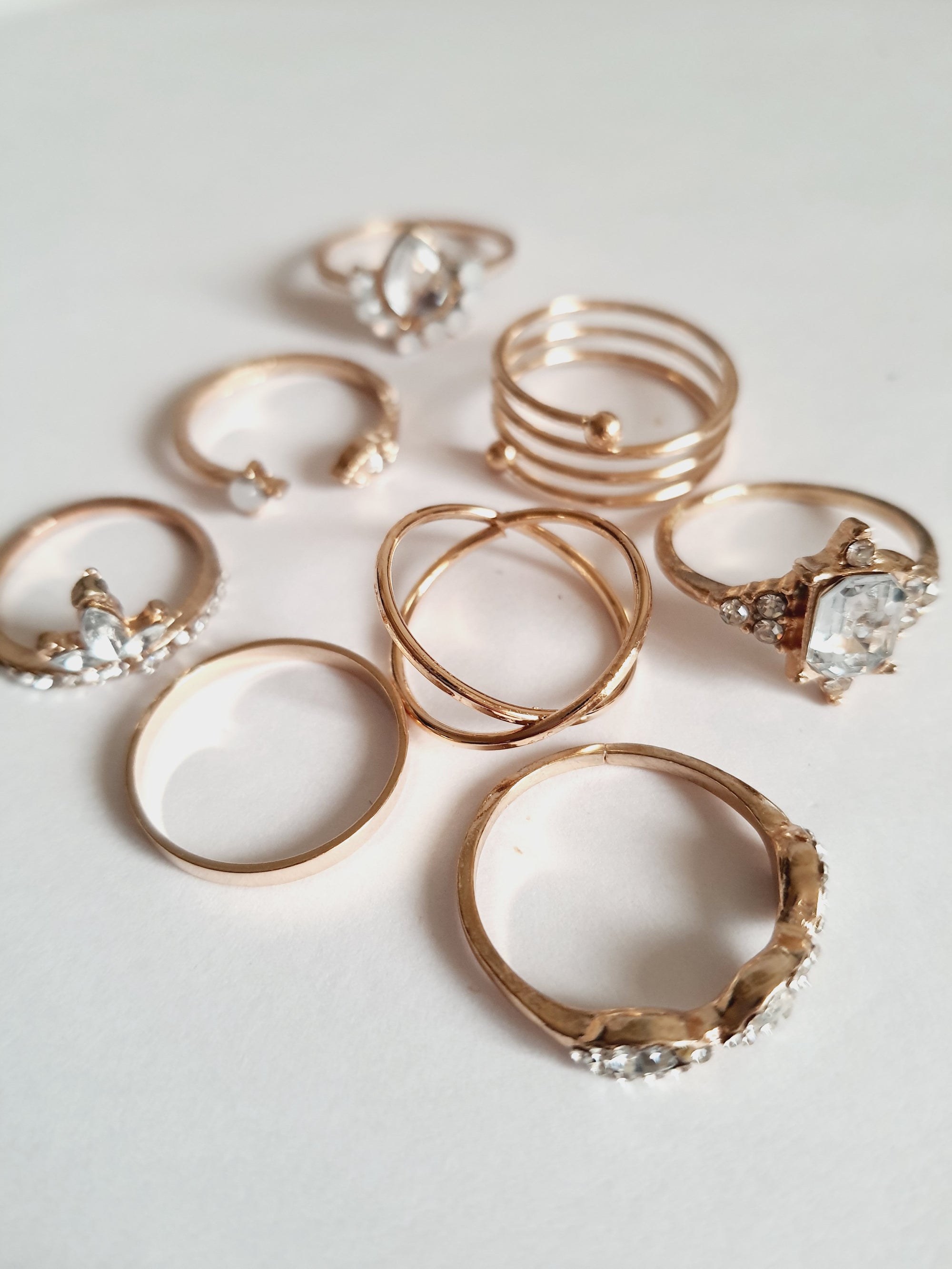 Zestaw 8 złotych pierścionków ze stali nierdzewnej i chirurgicznej, ozdobionych cyrkoniami i kryształkami w stylu glamour i klasycznym, rozmiary od 16 mm do 20 mm. Wodoodporne, hipoalergiczne, jakość premium. Rouge Bizu.