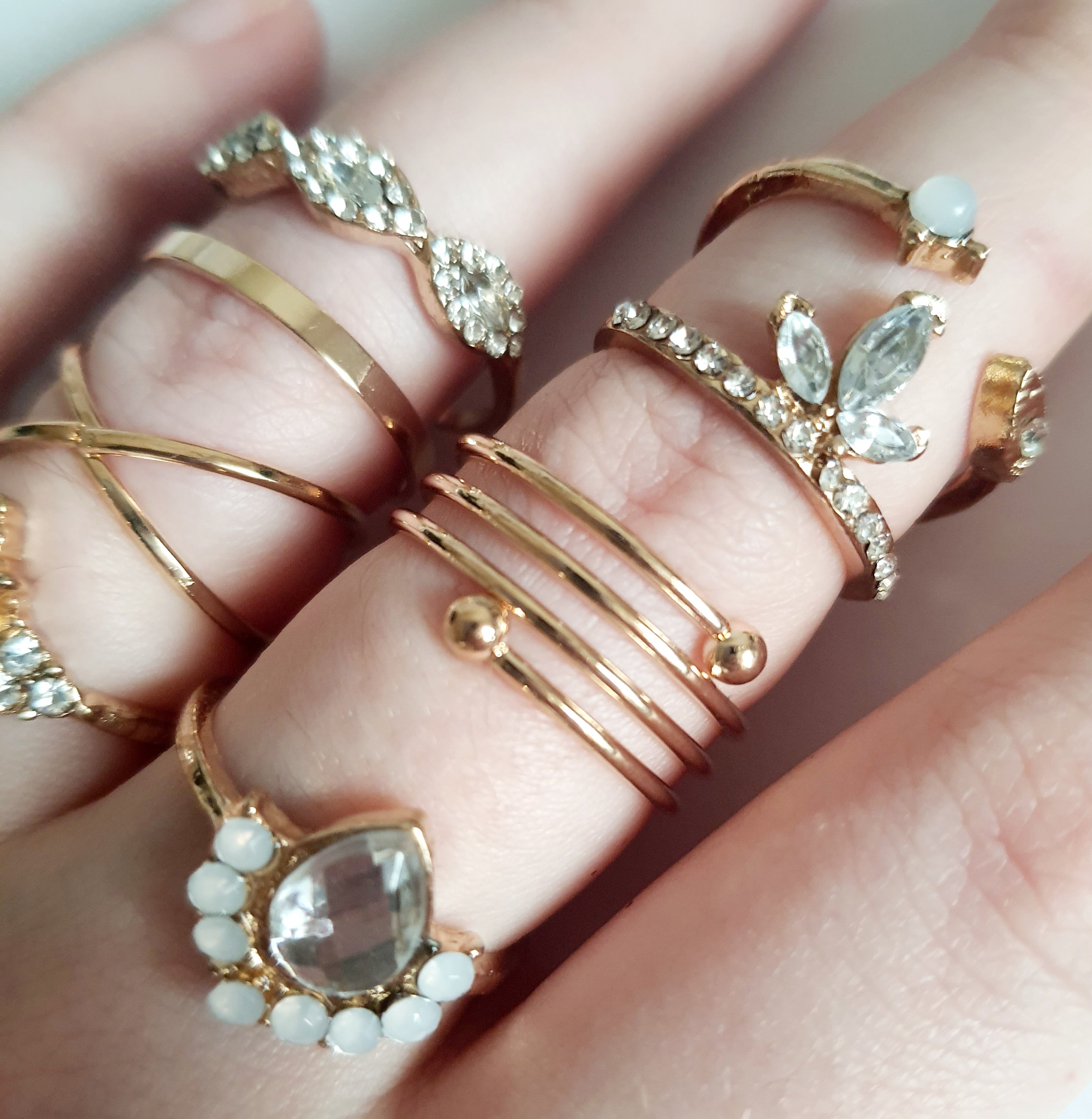 Zestaw 8 złotych pierścionków ze stali nierdzewnej i chirurgicznej, ozdobionych cyrkoniami i kryształkami w stylu glamour i klasycznym, rozmiary od 16 mm do 20 mm. Wodoodporne, hipoalergiczne, jakość premium. Rouge Bizu.