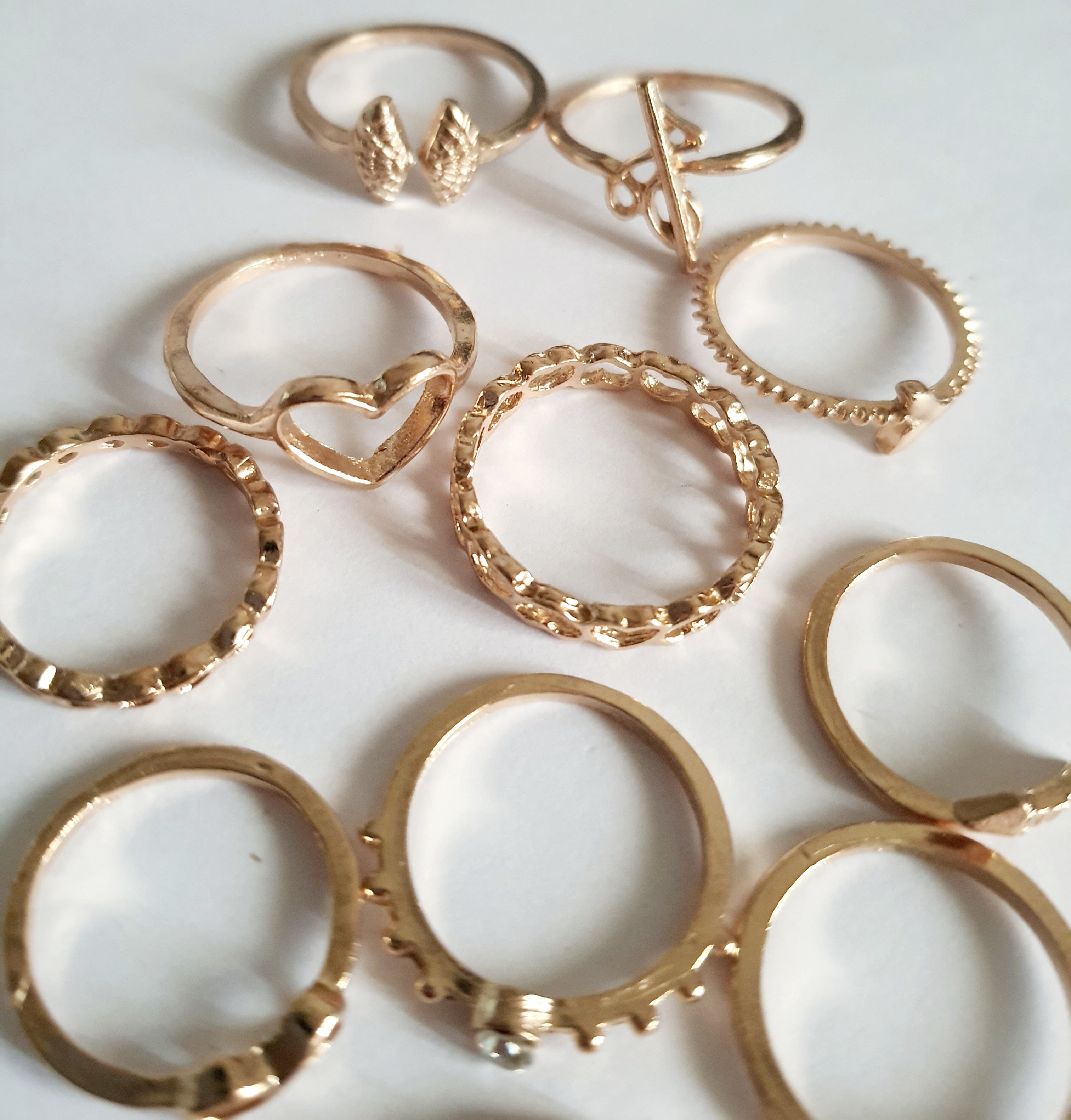 Zestaw 11 złotych pierścionków ze stali nierdzewnej i chirurgicznej w stylu minimalistycznym, z motywami serca, strzałki i skrzydeł, rozmiary od 16 mm do 20 mm. Wodoodporne, hipoalergiczne, jakość premium. Rouge Bizu.