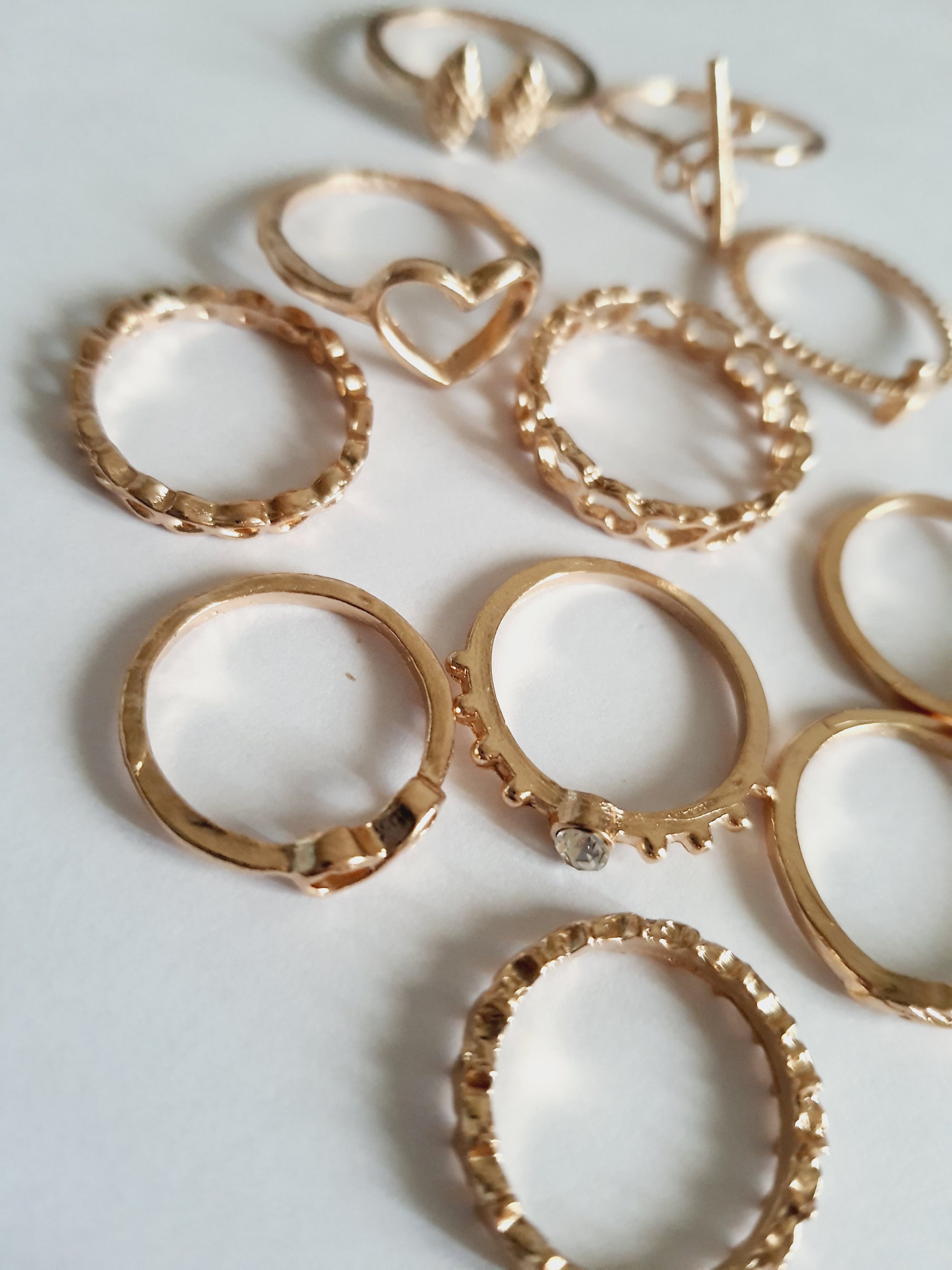 Zestaw 11 złotych pierścionków ze stali nierdzewnej i chirurgicznej w stylu minimalistycznym, z motywami serca, strzałki i skrzydeł, rozmiary od 16 mm do 20 mm. Wodoodporne, hipoalergiczne, jakość premium. Rouge Bizu.