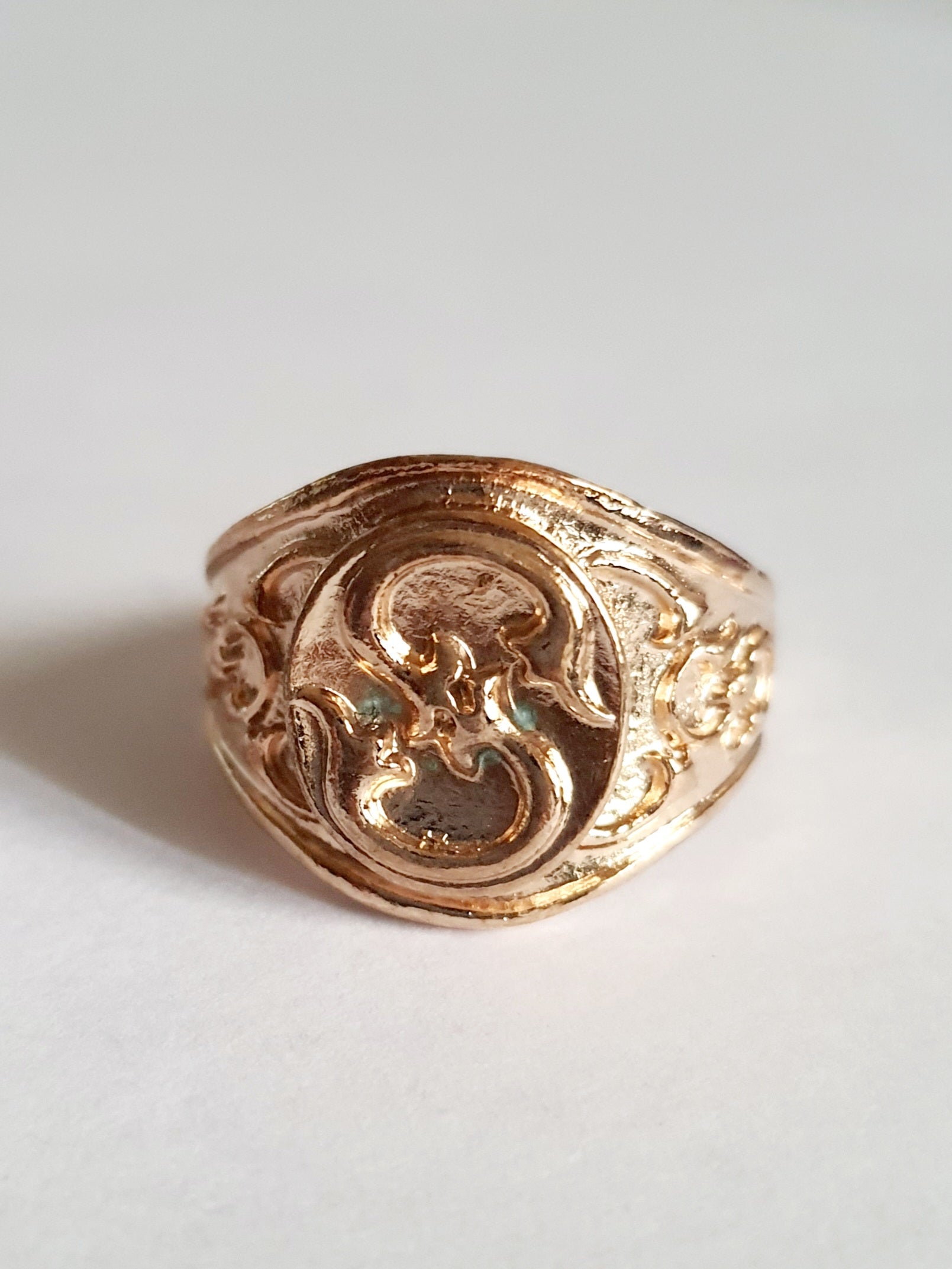 Złoty sygnet ze stali nierdzewnej i chirurgicznej, z ornamentowym reliefem w stylu vintage, rozmiar 19 mm. Wodoodporny, hipoalergiczny, jakość premium. Rouge Bizu.