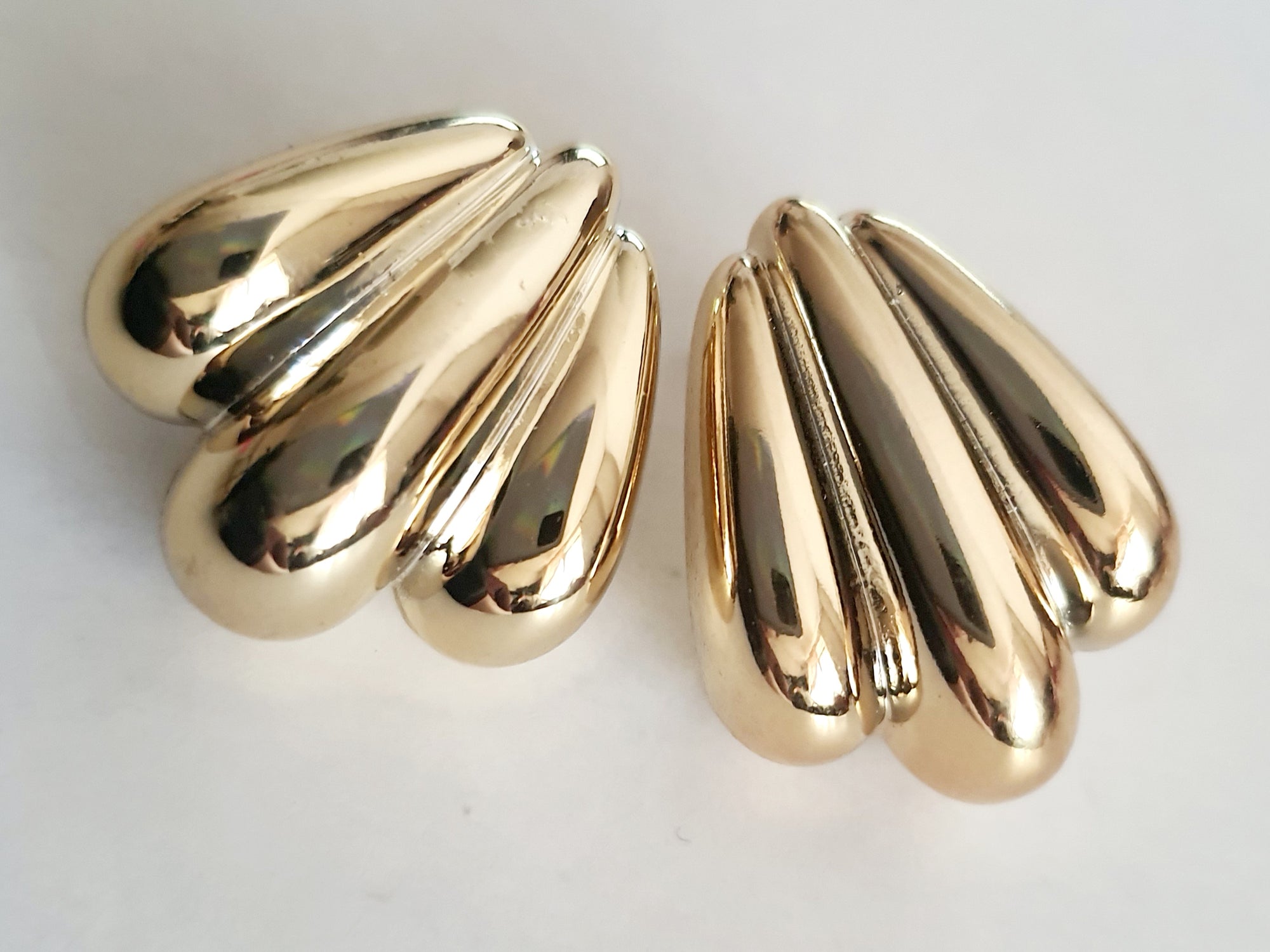 Kolczyki złote wkrętki o długości 2,5 cm, masywna forma przypominająca skrzydła lub rzeźbione łzy, styl vintage, glamour, stal chirurgiczna, elegancja i blask. Rouge Bizu.

