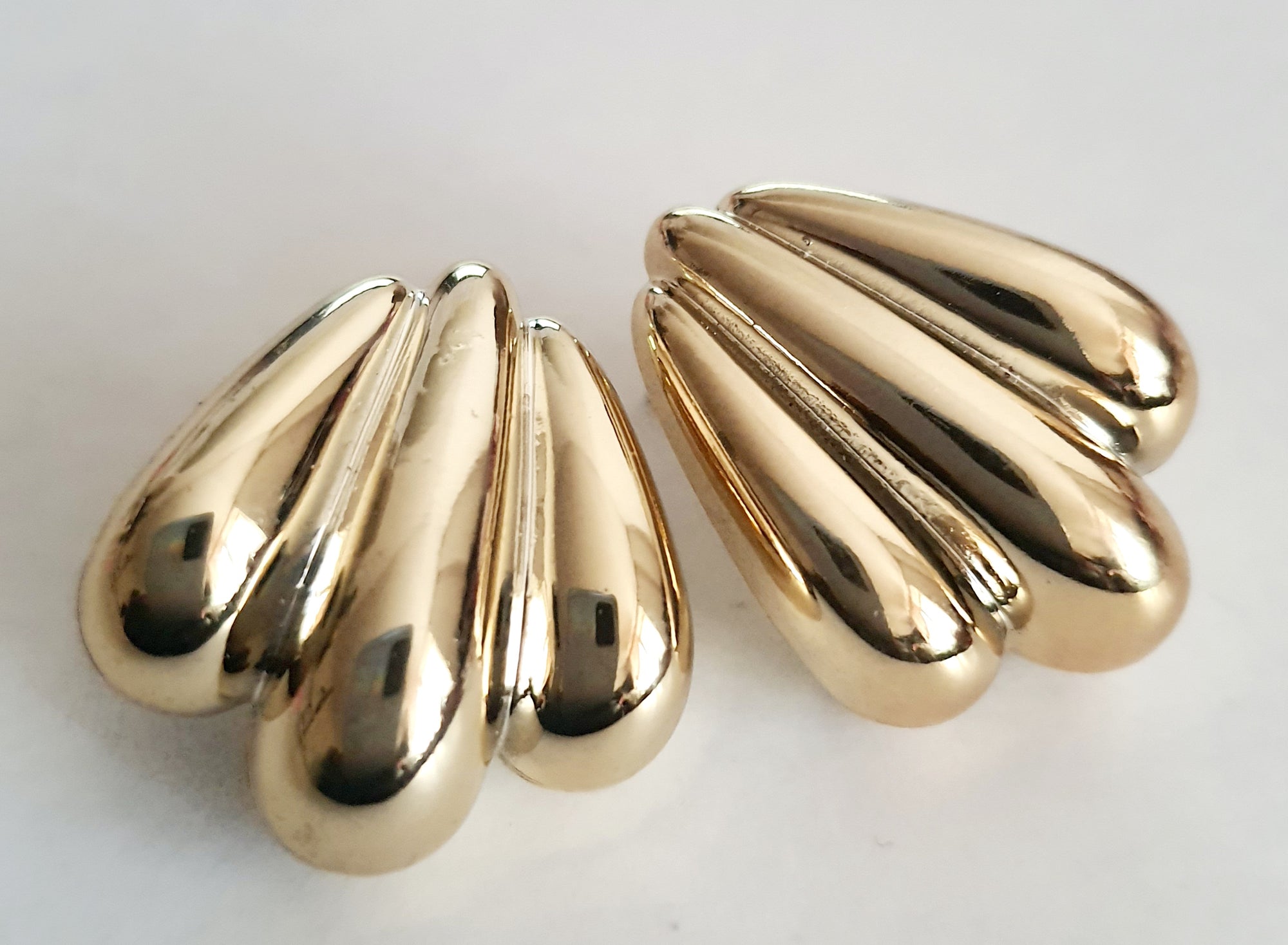 Kolczyki złote wkrętki o długości 2,5 cm, masywna forma przypominająca skrzydła lub rzeźbione łzy, styl vintage, glamour, stal chirurgiczna, elegancja i blask. Rouge Bizu.

