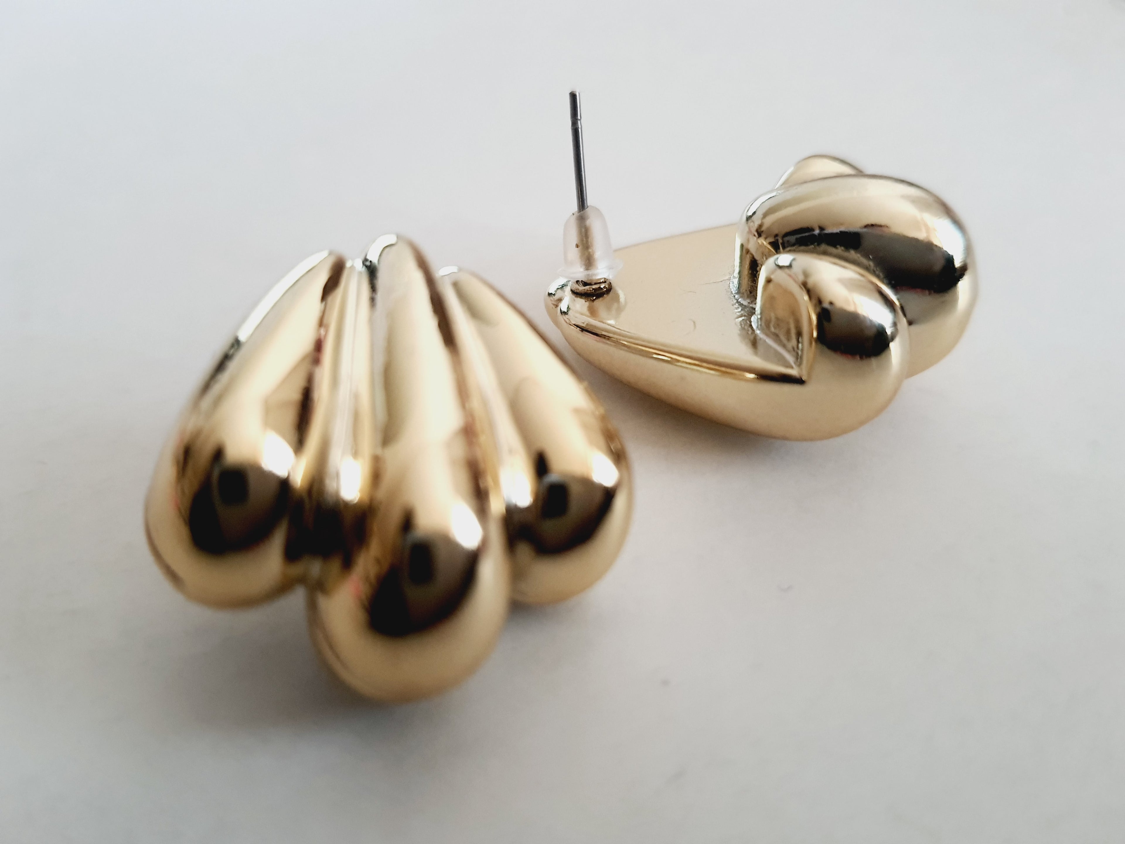 Kolczyki złote wkrętki o długości 2,5 cm, masywna forma przypominająca skrzydła lub rzeźbione łzy, styl vintage, glamour, stal chirurgiczna, elegancja i blask. Rouge Bizu.

