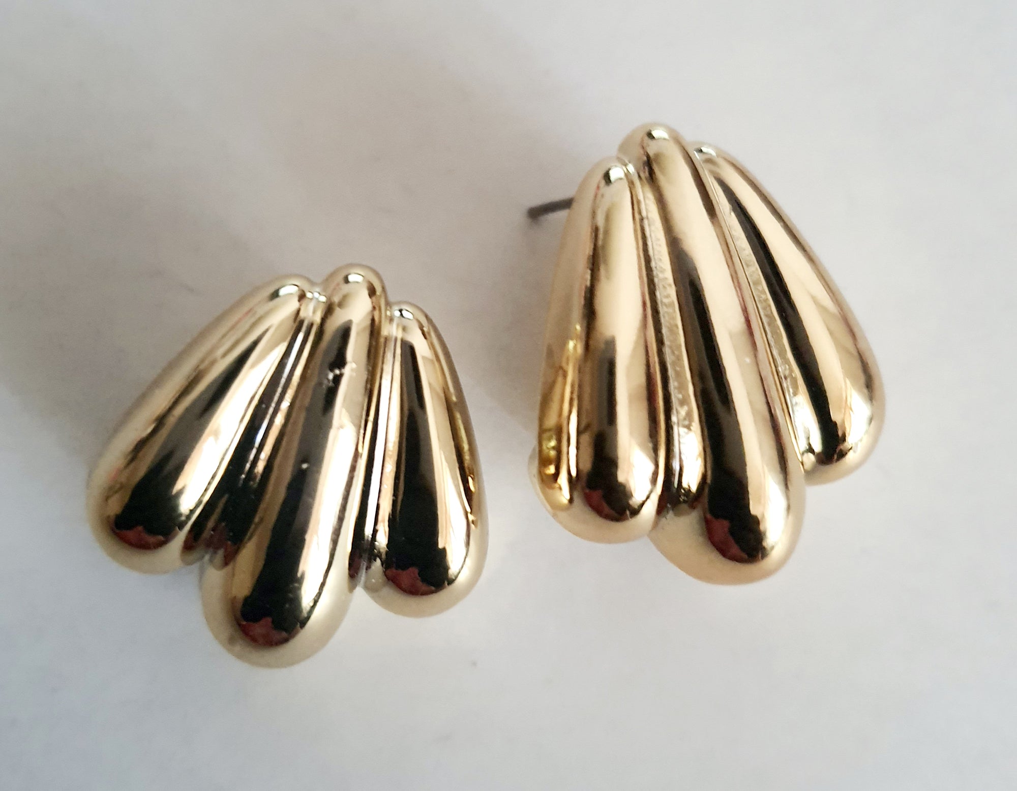 Kolczyki złote wkrętki o długości 2,5 cm, masywna forma przypominająca skrzydła lub rzeźbione łzy, styl vintage, glamour, stal chirurgiczna, elegancja i blask. Rouge Bizu.

