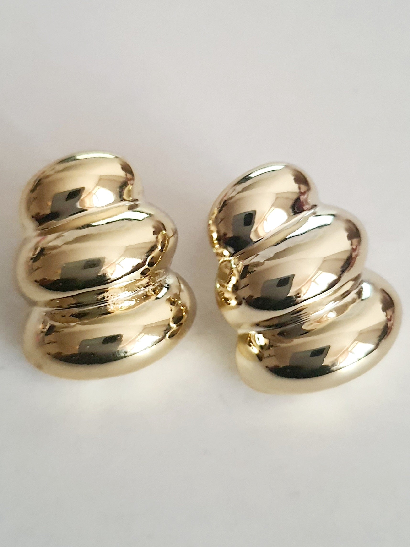 Kolczyki złote wkrętki o długości 2 cm, z rzeźbiarskimi, opływowymi formami przypominającymi obłoki. Minimalistyczne, retro glamour, stal chirurgiczna, elegancja i charakter. Rouge Bizu.

