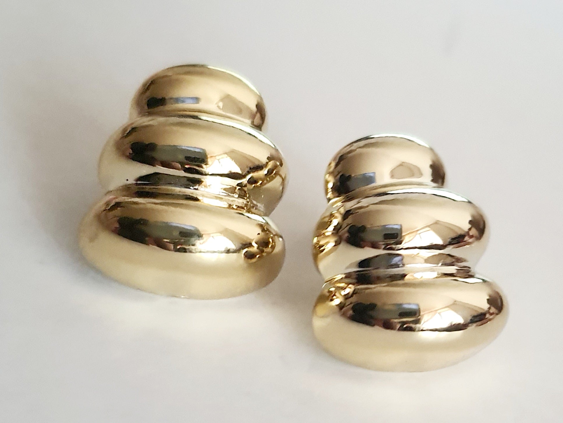 Kolczyki złote wkrętki o długości 2 cm, z rzeźbiarskimi, opływowymi formami przypominającymi obłoki. Minimalistyczne, retro glamour, stal chirurgiczna, elegancja i charakter. Rouge Bizu.

