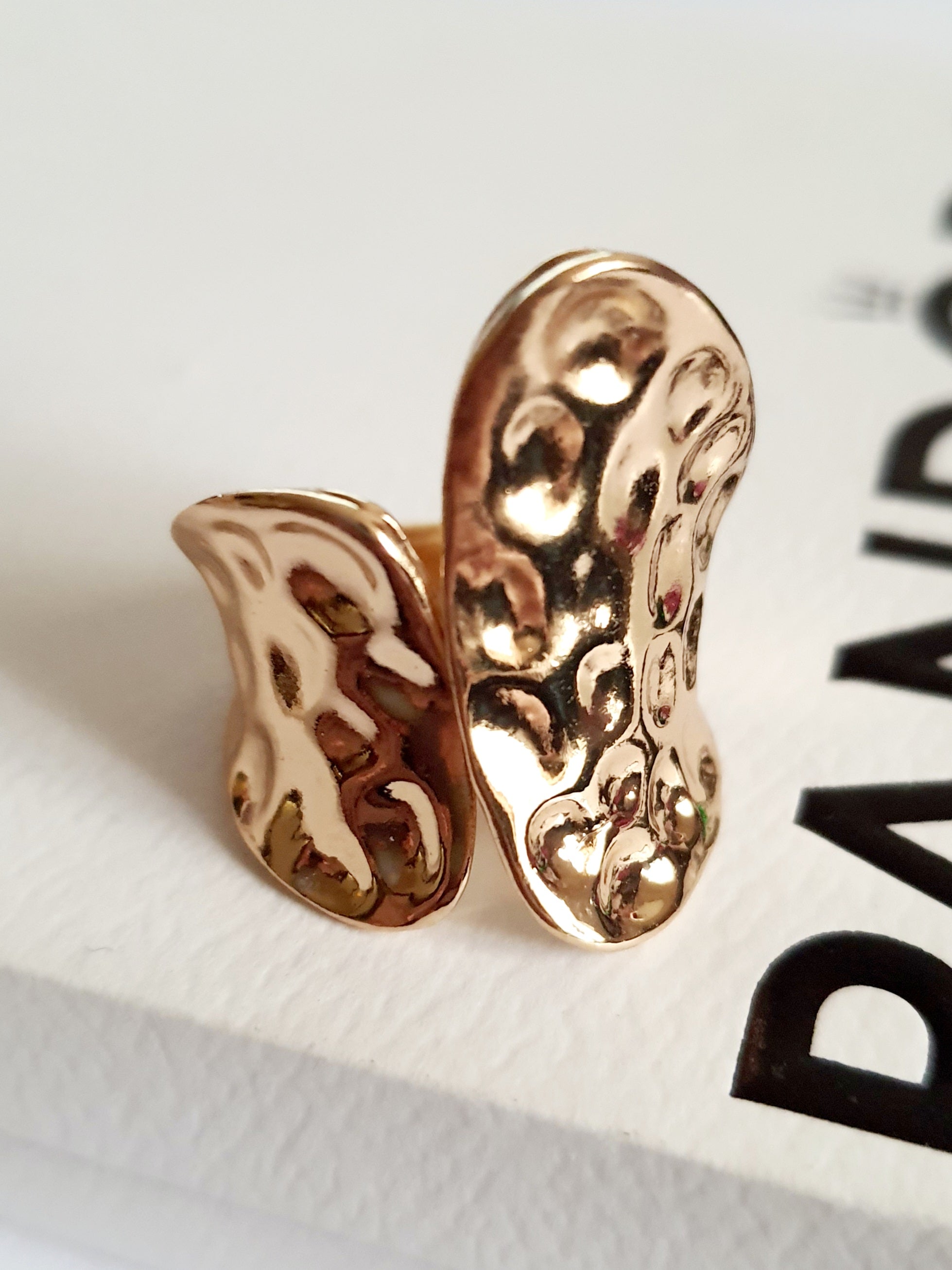 Pierścionek rzeźbiarski z żółtego złota, nieregularna tekstura, połyskująca powierzchnia, stal nierdzewna, rozmiar 17 mm, nowoczesna elegancja. Rouge Bizu.

