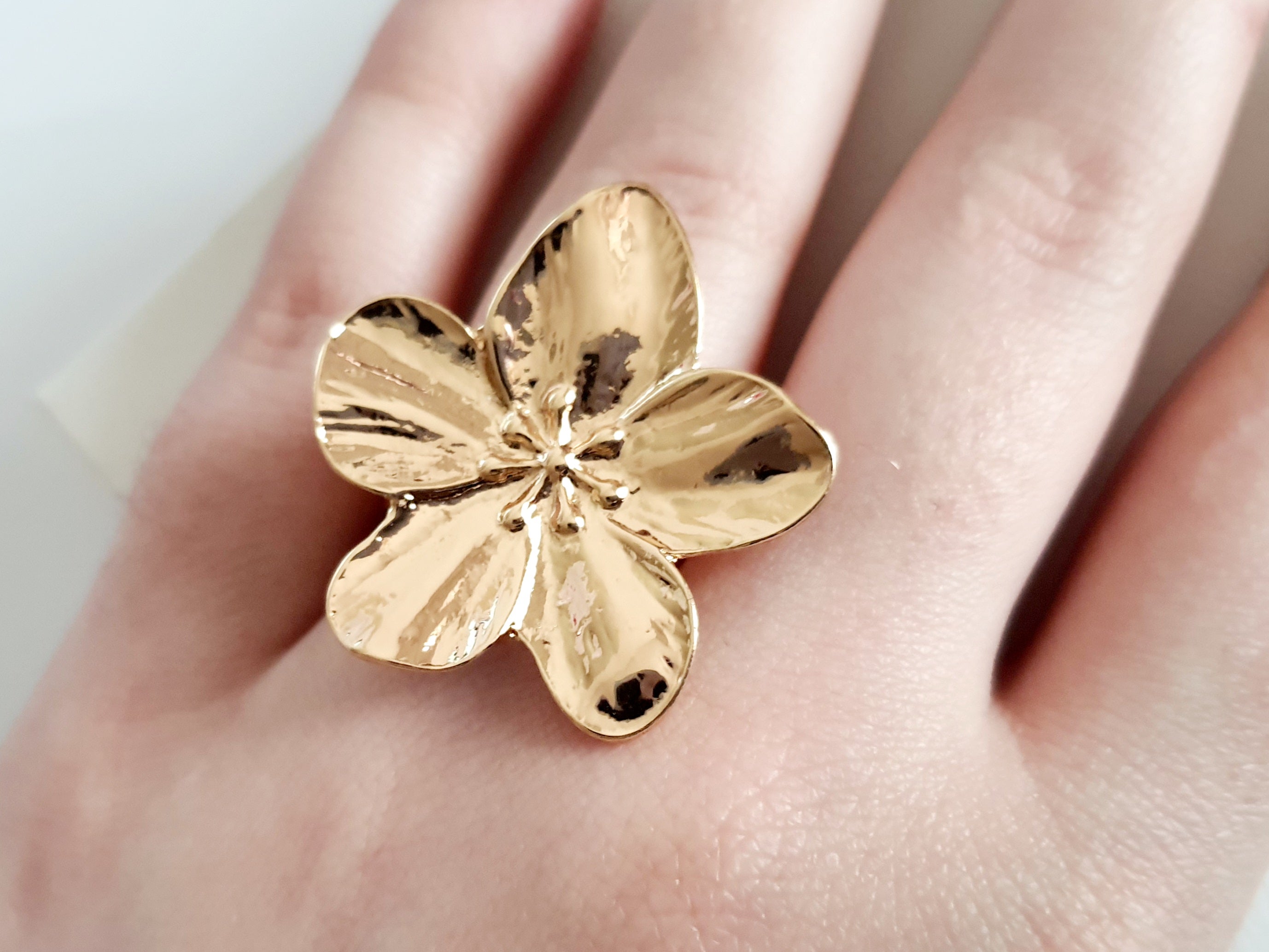 Pierścionek w kształcie dużego złotego kwiatu, błyszczący, rzeźbiony, botaniczny styl, stal nierdzewna, rozmiar 18 mm. Rouge Bizu.

