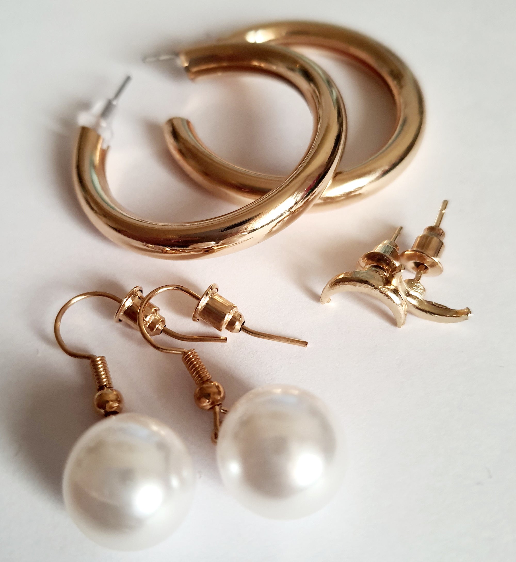 Stylowy zestaw trzech par kolczyków, który pozwala tworzyć różnorodne stylizacje – od minimalistycznej elegancji po delikatny romantyzm. stal nierdzewna. klasyczne kółka, wiszące perełki i wkręty z księzycem. rouge bizu