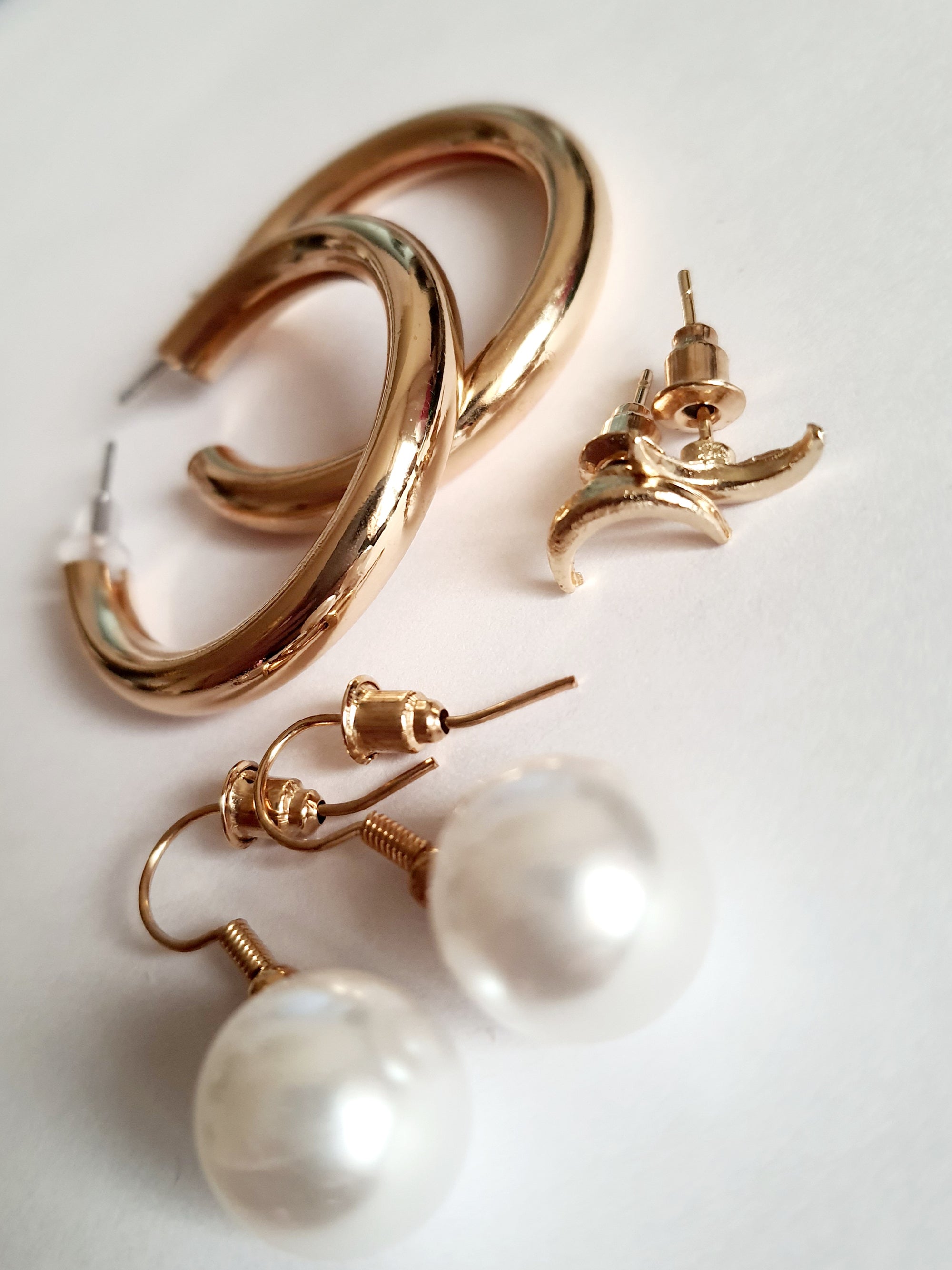 Stylowy zestaw trzech par kolczyków, który pozwala tworzyć różnorodne stylizacje – od minimalistycznej elegancji po delikatny romantyzm. stal nierdzewna. klasyczne kółka, wiszące perełki i wkręty z księzycem. rouge bizu
