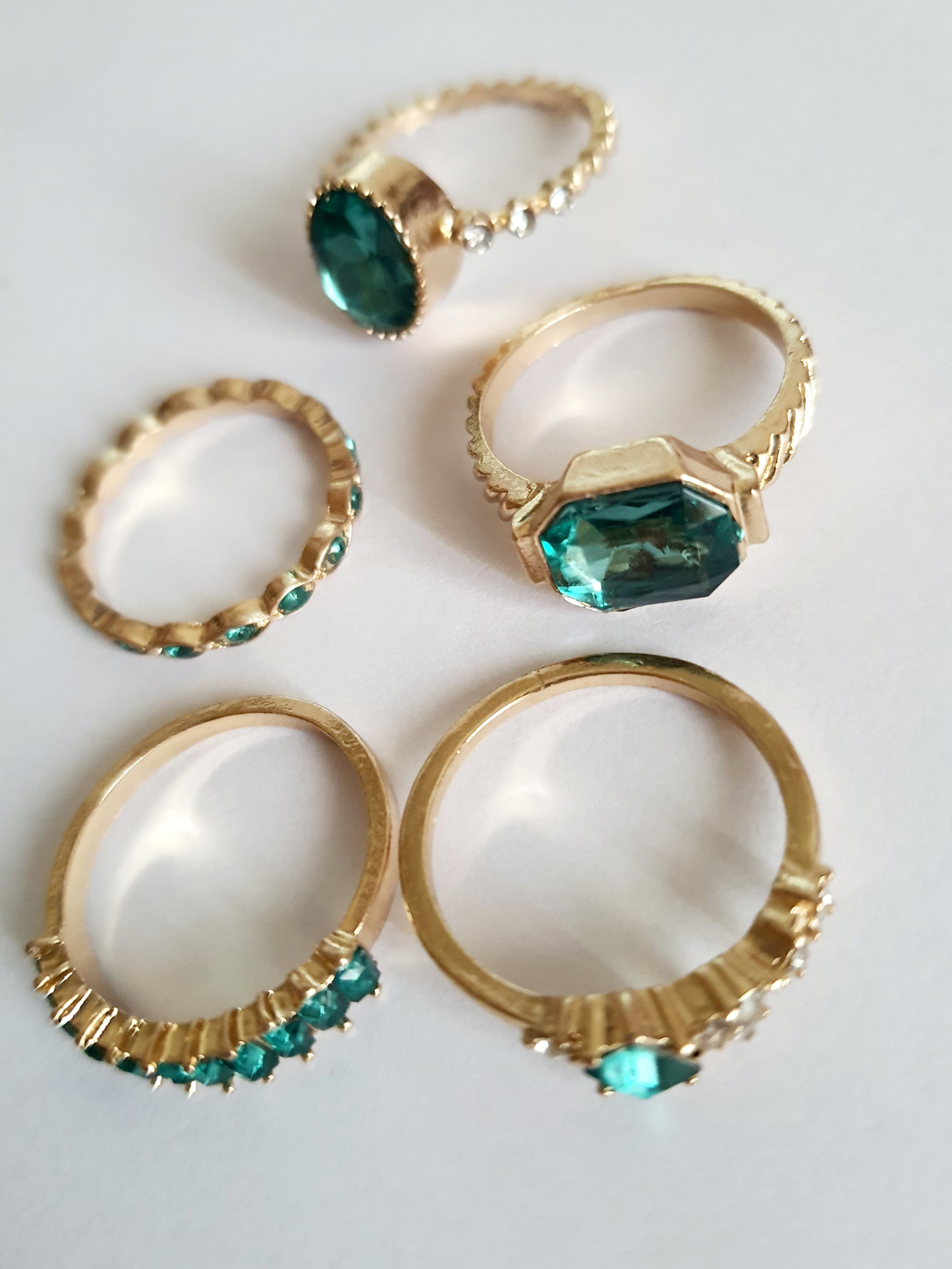 Zestaw pięciu pierścionków w odcieniu szmaragdu na białym tle. Wykonane ze stali nierdzwnej, chirurgicznej, rozmiary od 7mm do 20mm. Elegancja i paryski szyk