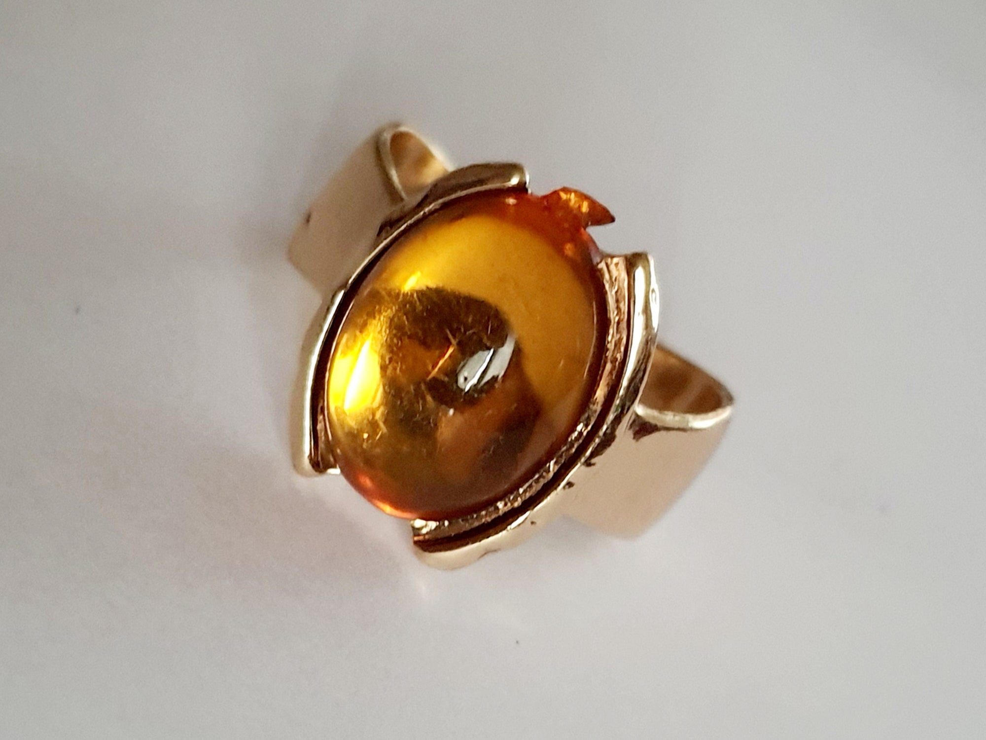 Złoty pierścionek z bursztynowym oczkiem na palcu, stal nierdzewna, stal chirurgiczna. klasyczna elegancja, vintage vibe. rouge bizu