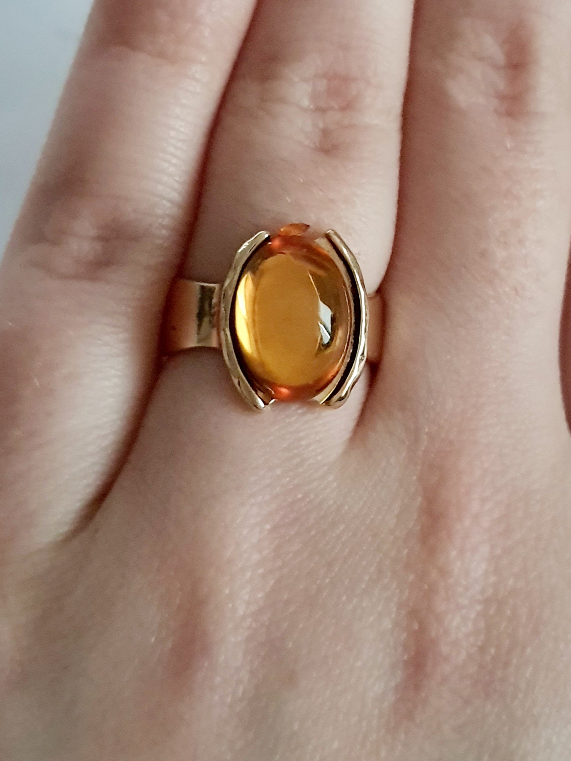 Złoty pierścionek z bursztynowym oczkiem na palcu, stal nierdzewna, stal chirurgiczna. klasyczna elegancja, vintage vibe. rouge bizu