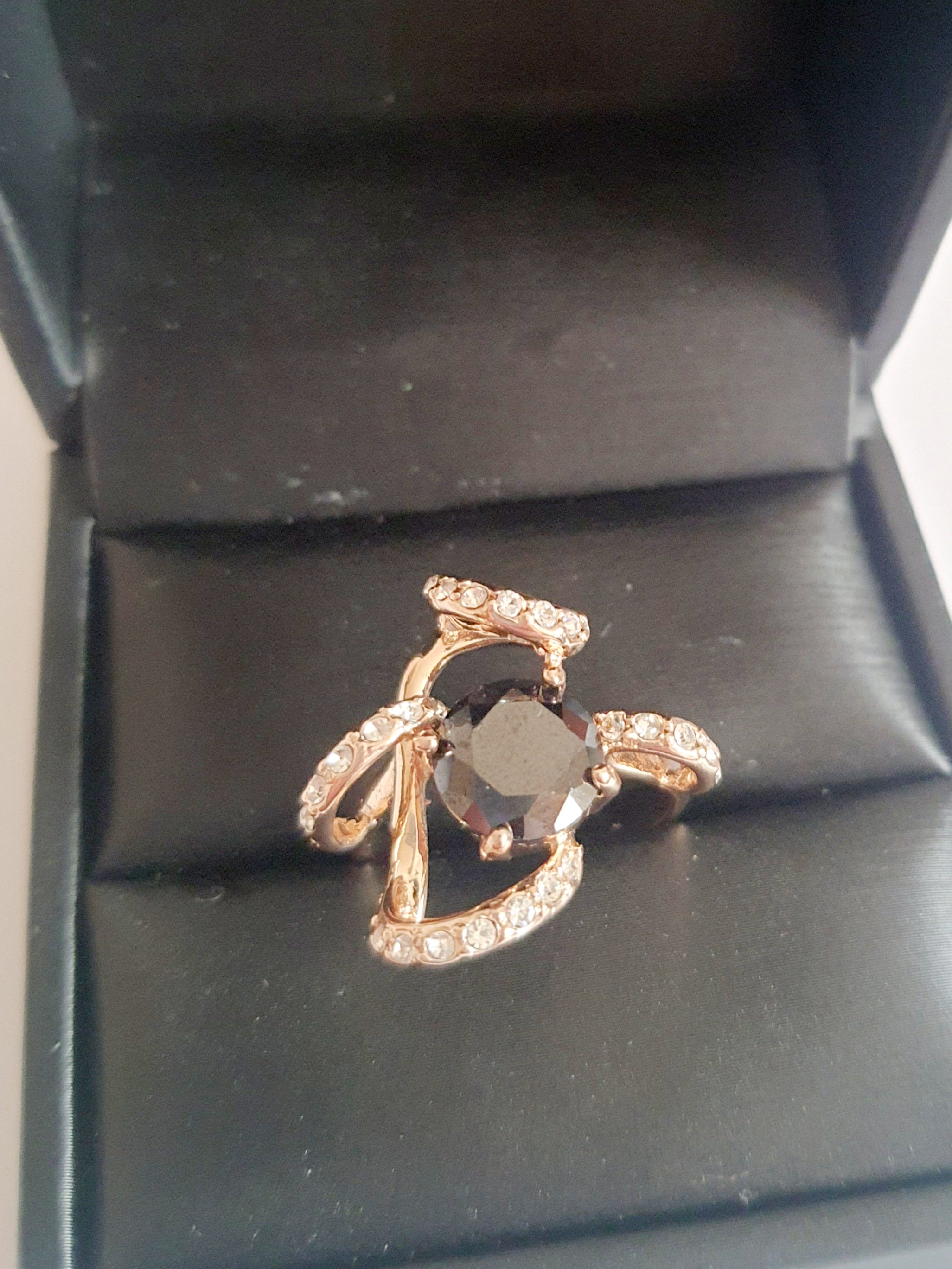 Pierścionek ze złota różowego z dużym czarnym kamieniem w centrum i zdobieniami z drobnych cyrkonii. Styl glamour, rozmiar 18 mm. Elegancki, efektowny, wykonany ze stali chirurgicznej. Rouge Bizu.

