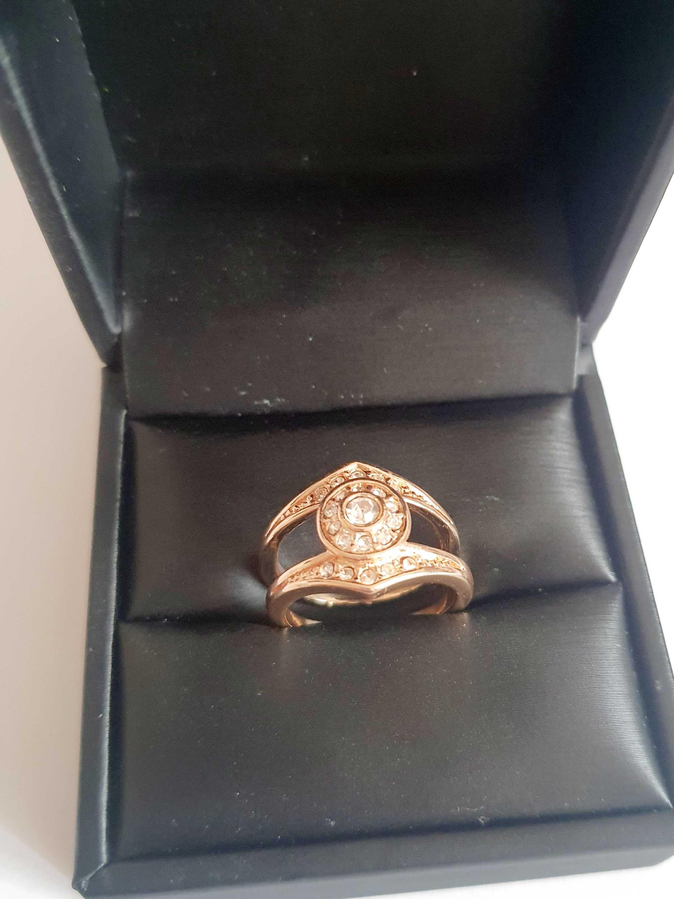 Złoty pierścionek ze stali chirurgicznej z okrągłym bezbarwnym kryształem w centrum, otoczonym drobnymi cyrkoniami. Podwójna obrączka, klasyczny styl. Rozmiar 16 mm. Rouge Bizu.

