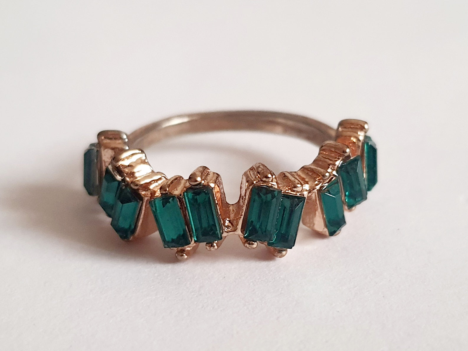 Pierścionek ze stali chirurgicznej w kolorze żółtego złota, ozdobiony szmaragdowymi kryształami typu baguette w górnej części obrączki. Styl minimalistyczny glamour. Rozmiar 18 mm. Rouge Bizu.

