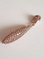 Wisiorek ze stali chirurgicznej w kolorze różowego złota, długość 4 cm, w kształcie kropli wysadzanej drobnymi cyrkoniami. Elegancki połysk, nowoczesny glamour. Rouge Bizu.


