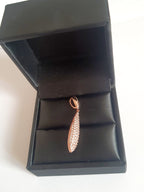 Wisiorek ze stali chirurgicznej w kolorze różowego złota, długość 4 cm, w kształcie kropli wysadzanej drobnymi cyrkoniami. Elegancki połysk, nowoczesny glamour. Rouge Bizu.

