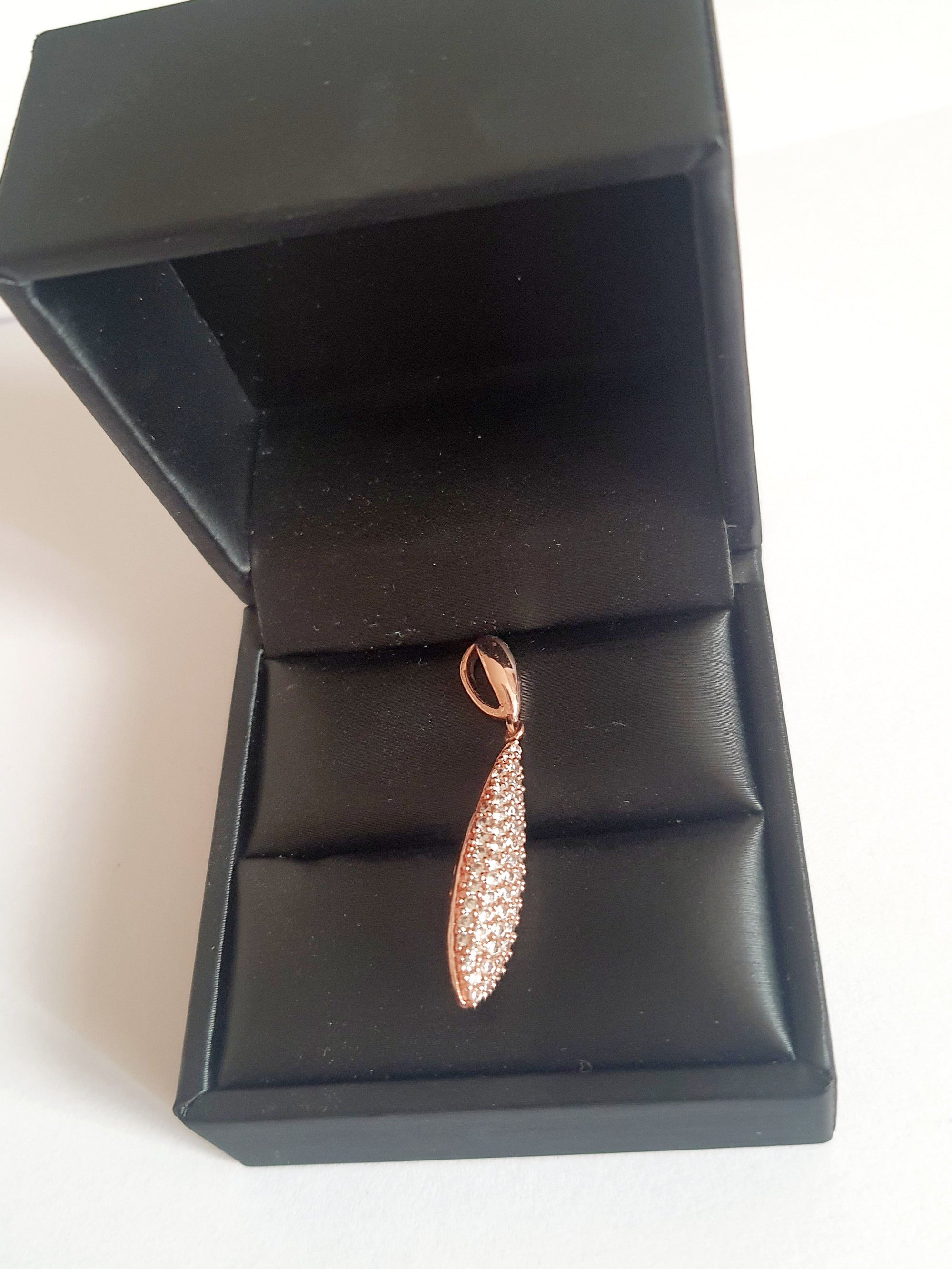 Wisiorek ze stali chirurgicznej w kolorze różowego złota, długość 4 cm, w kształcie kropli wysadzanej drobnymi cyrkoniami. Elegancki połysk, nowoczesny glamour. Rouge Bizu.

