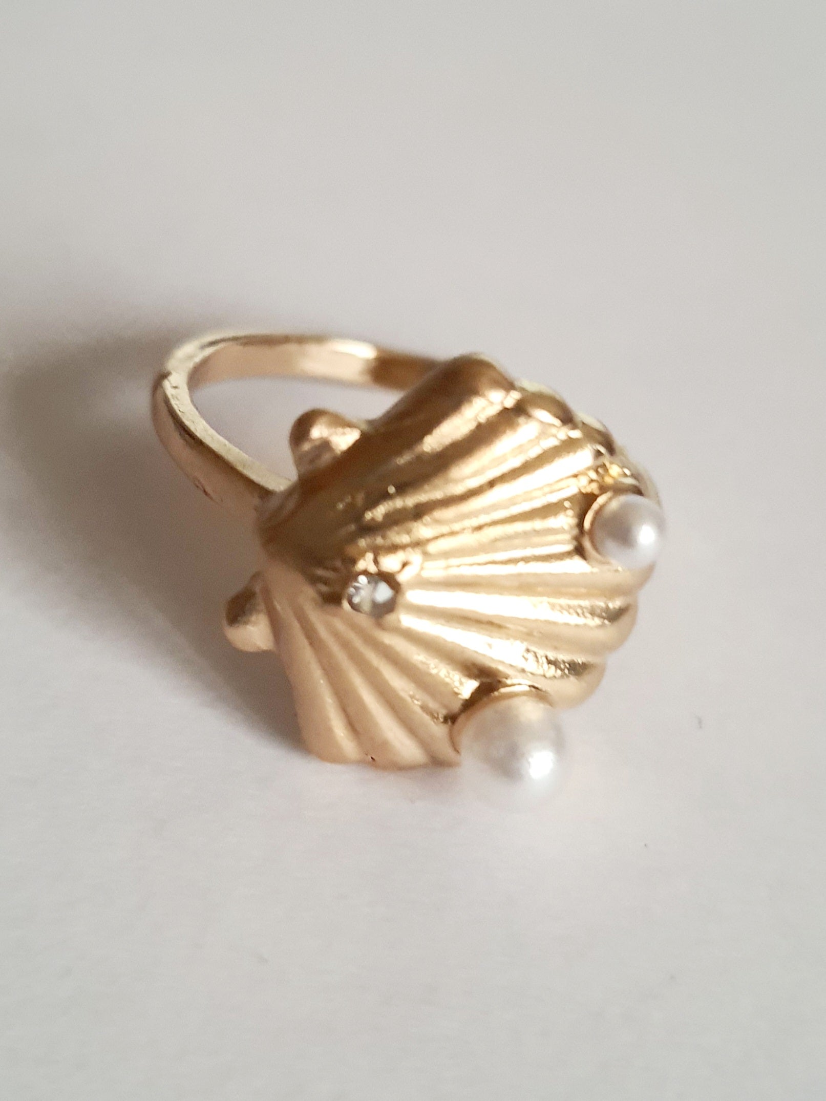 Pierścionek w kształcie złotej muszli z perełkami i cyrkonią. Styl vintage glamour. Rozmiar 17 mm. Stal nierdzewna, elegancja i morska nostalgia. Rouge Bizu.

