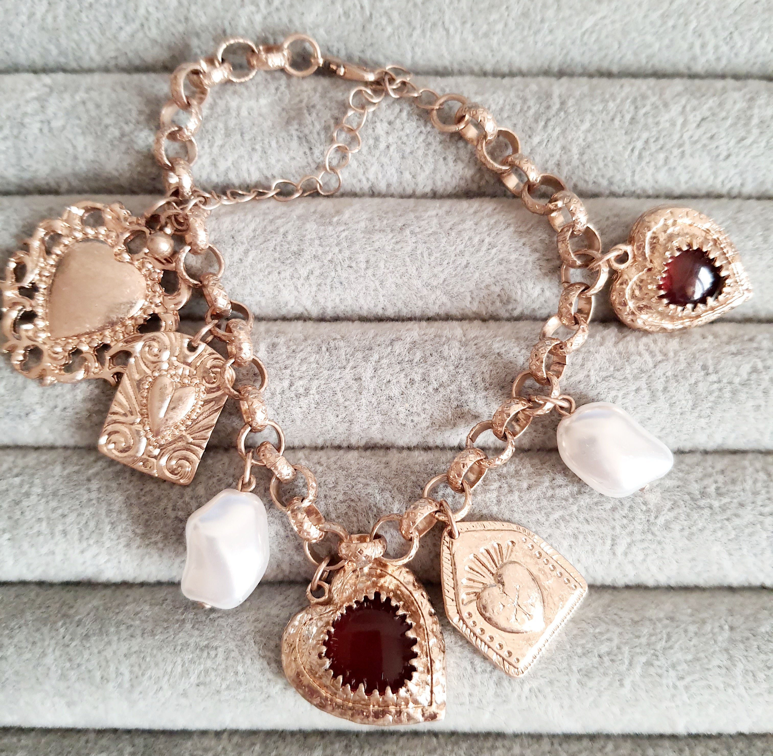 Złota bransoletka w stylu vintage z charmsami: serca, symbole sakralne, perłowe zawieszki. Stal chirurgiczna, długość regulowana 20–28 cm. Klasyka, romantyzm i mistyczna elegancja. Rouge Bizu.

