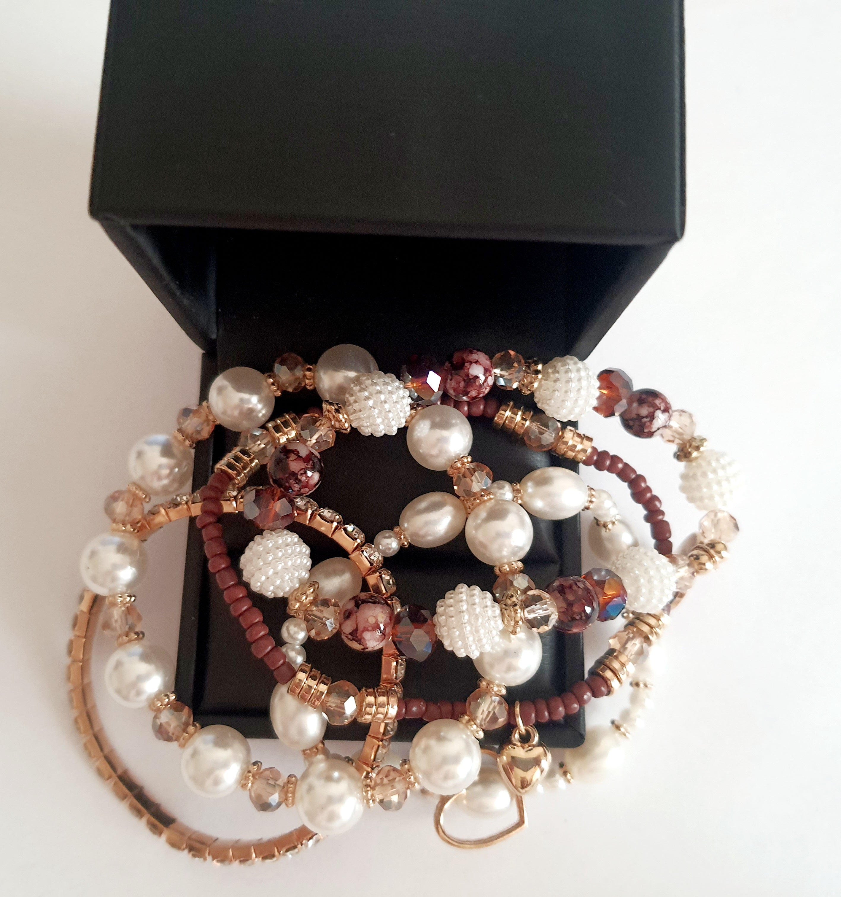 Zestaw pięciu elastycznych bransoletek na gumce z perłami, szkłem, kryształkami i złotymi akcentami. Styl romantyczny i boho. Zawieszka w kształcie serca. Wygodne dopasowanie. Rouge Bizu.

