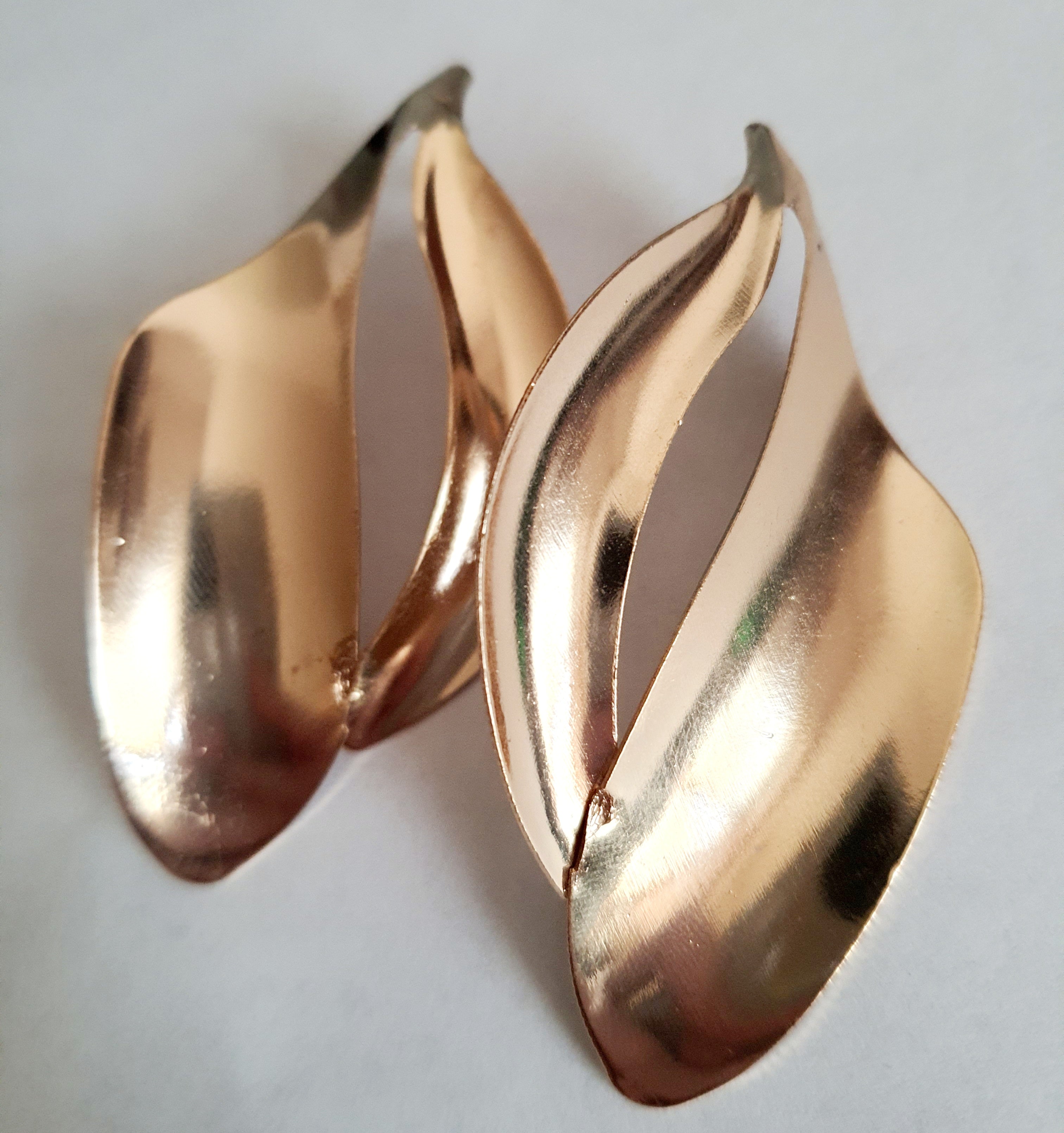 Kolczyki ze stali nierdzewnej w kolorze złotym o rzeźbiarskim kształcie fal. Długość 7 cm, na wkrętki. Eleganckie, lekkie i nowoczesne. Rouge Bizu.

