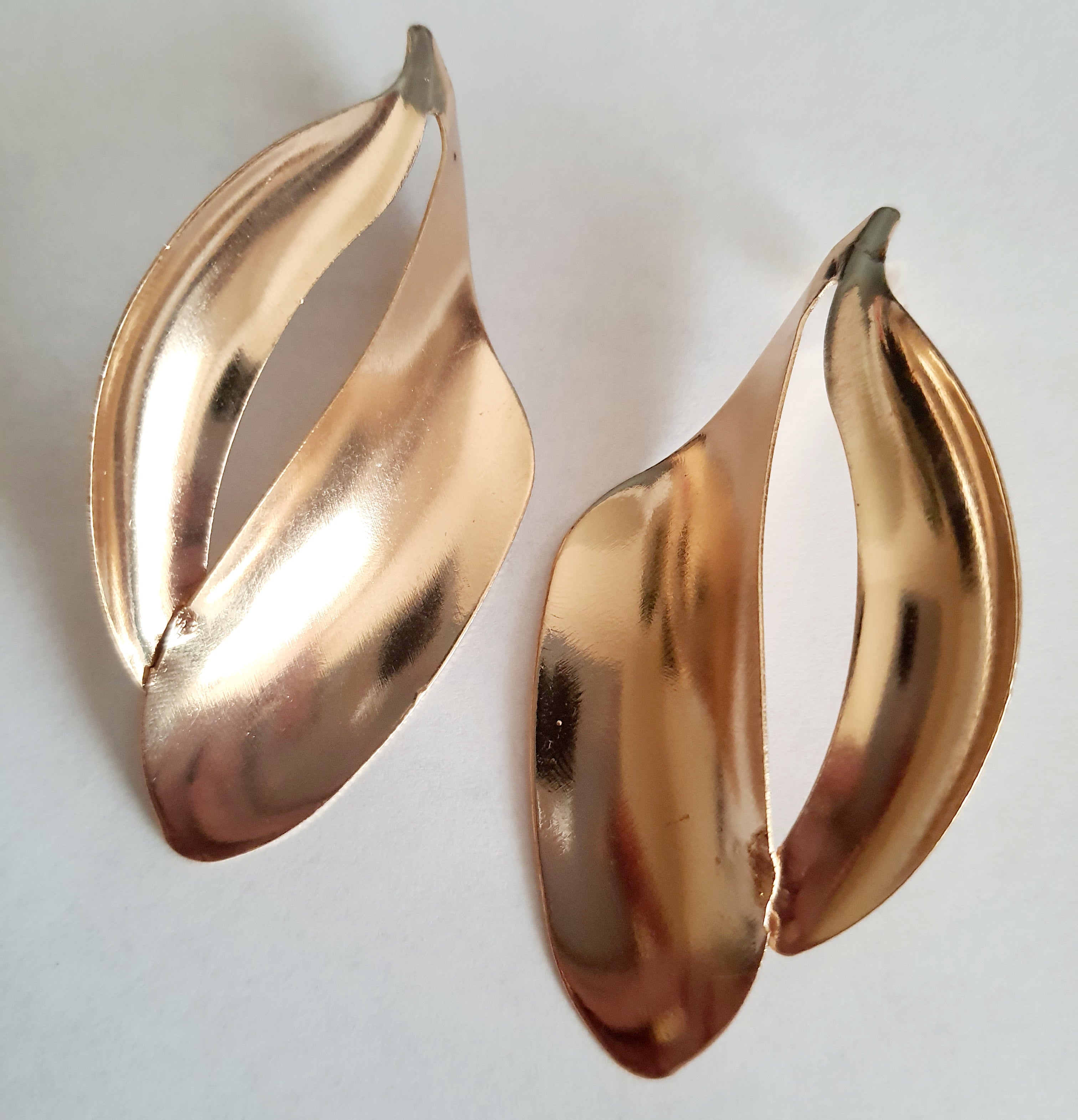 Kolczyki ze stali nierdzewnej w kolorze złotym o rzeźbiarskim kształcie fal. Długość 7 cm, na wkrętki. Eleganckie, lekkie i nowoczesne. Rouge Bizu.

