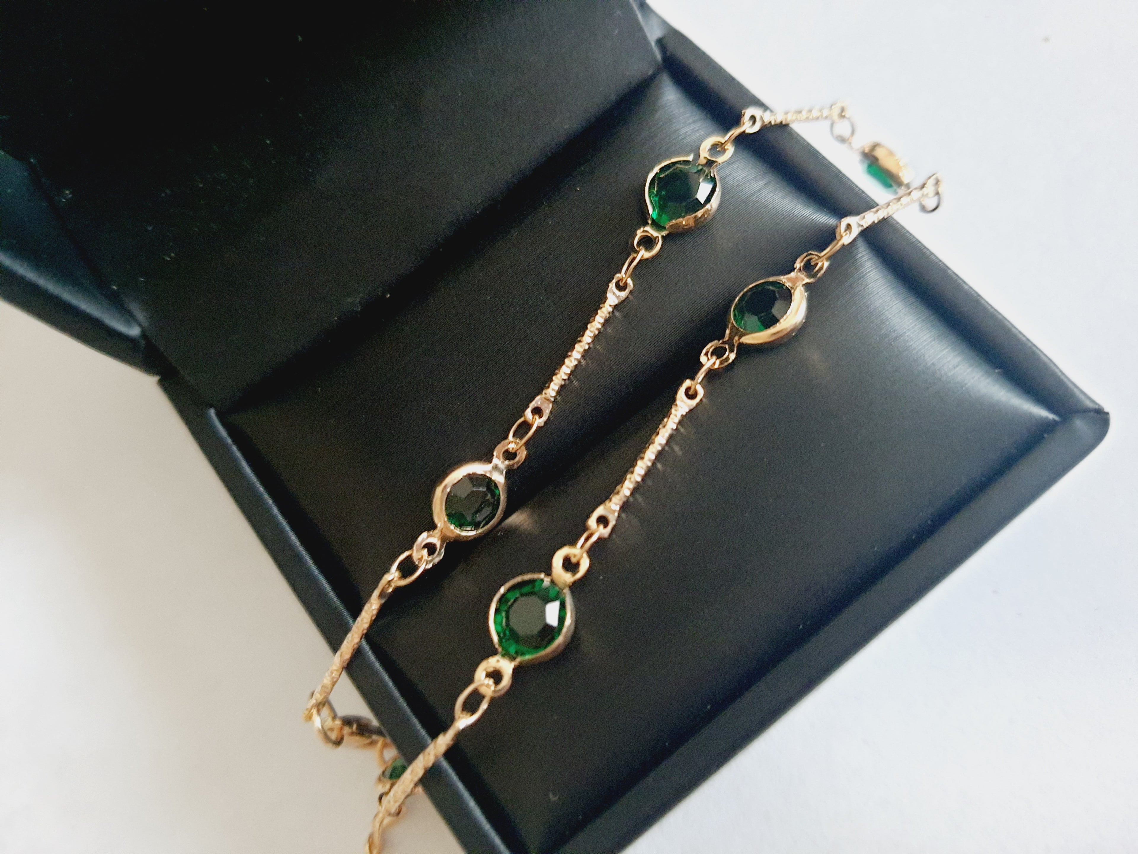 Bransoletka z szmaragdowymi cyrkoniami, złoty łańcuszek, regulowana długość 20–25 cm. Delikatna, elegancka, klasyczna biżuteria ze stali nierdzewnej. Rouge Bizu.

